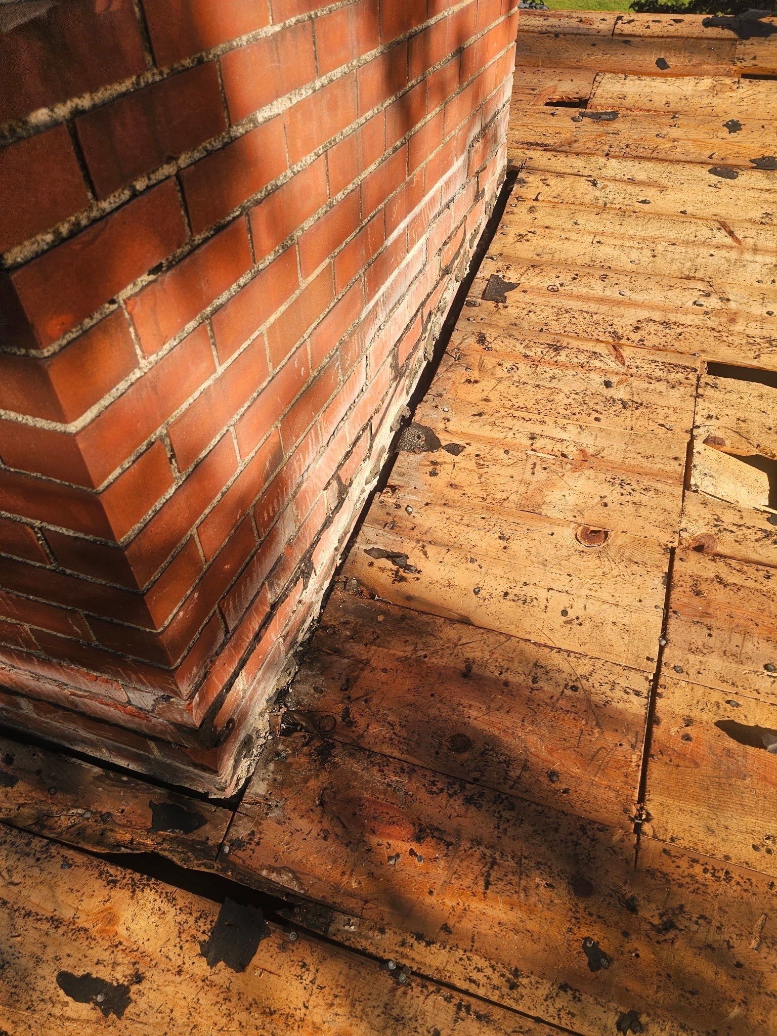 The plank deck at the base of the brick chimney after tear-off, Kettering, Ohio.