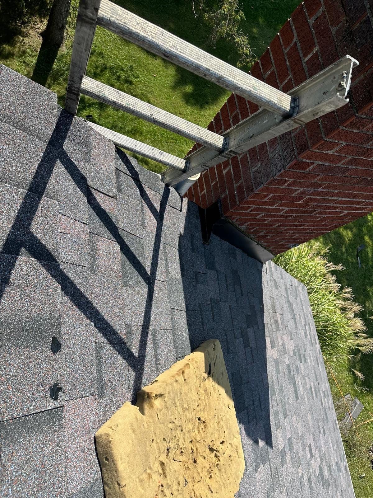 Finished shingles around the base of the chimney, with a ladder beside it, Beavercreek, Ohio.