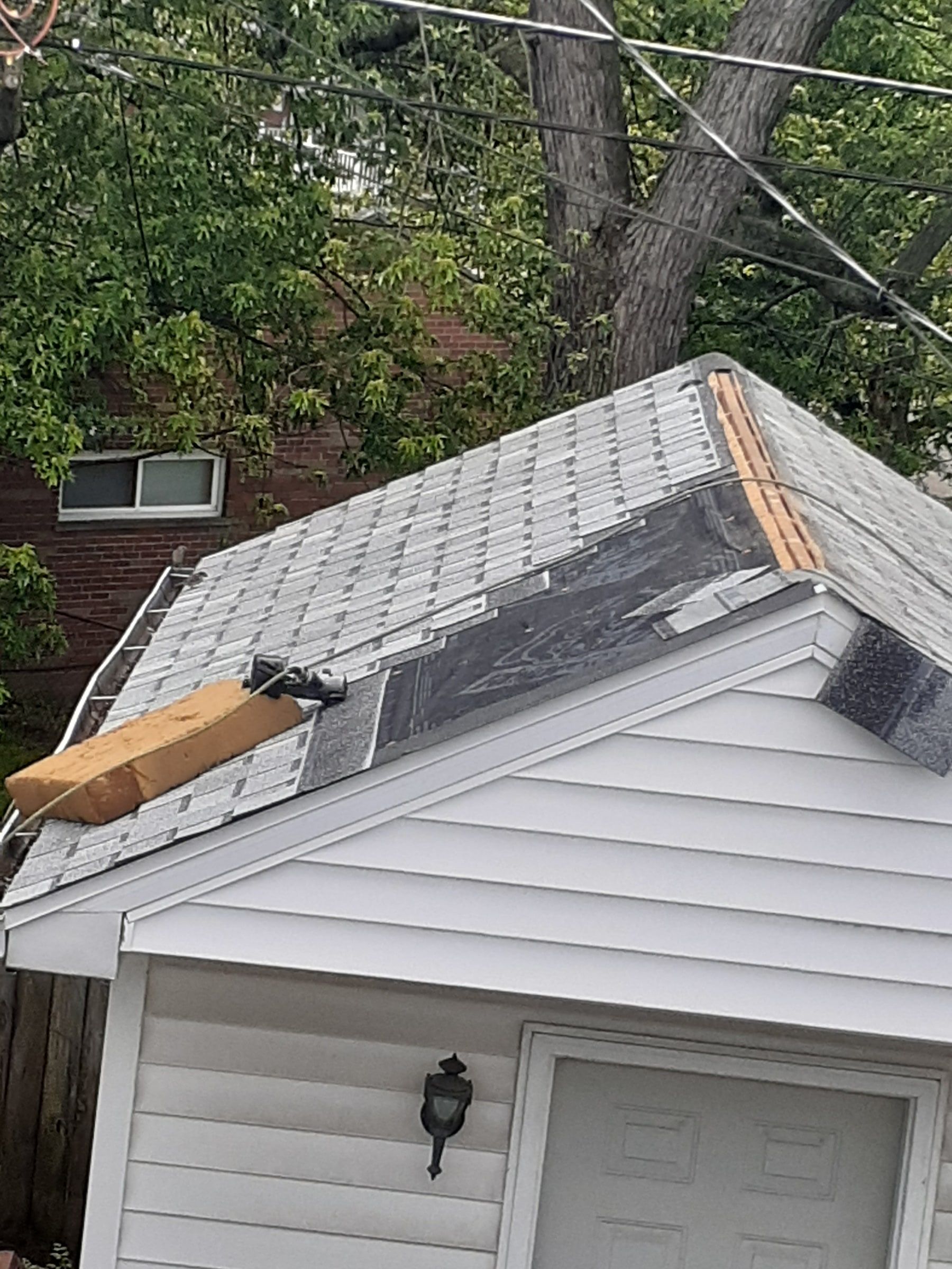 New shingles going on the garage roof toward its ridge, Huber Heights, Ohio.