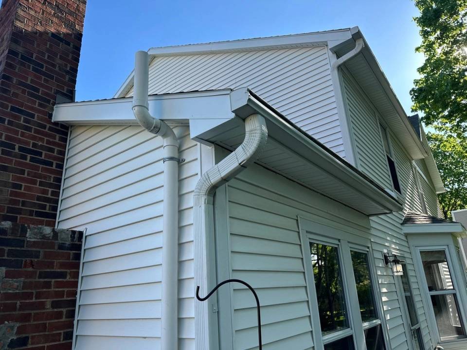 New fascia, soffit and gutters with two downspouts at the rear corner of a house on Sugar Leaf Dr, Bellbrook, Ohio.