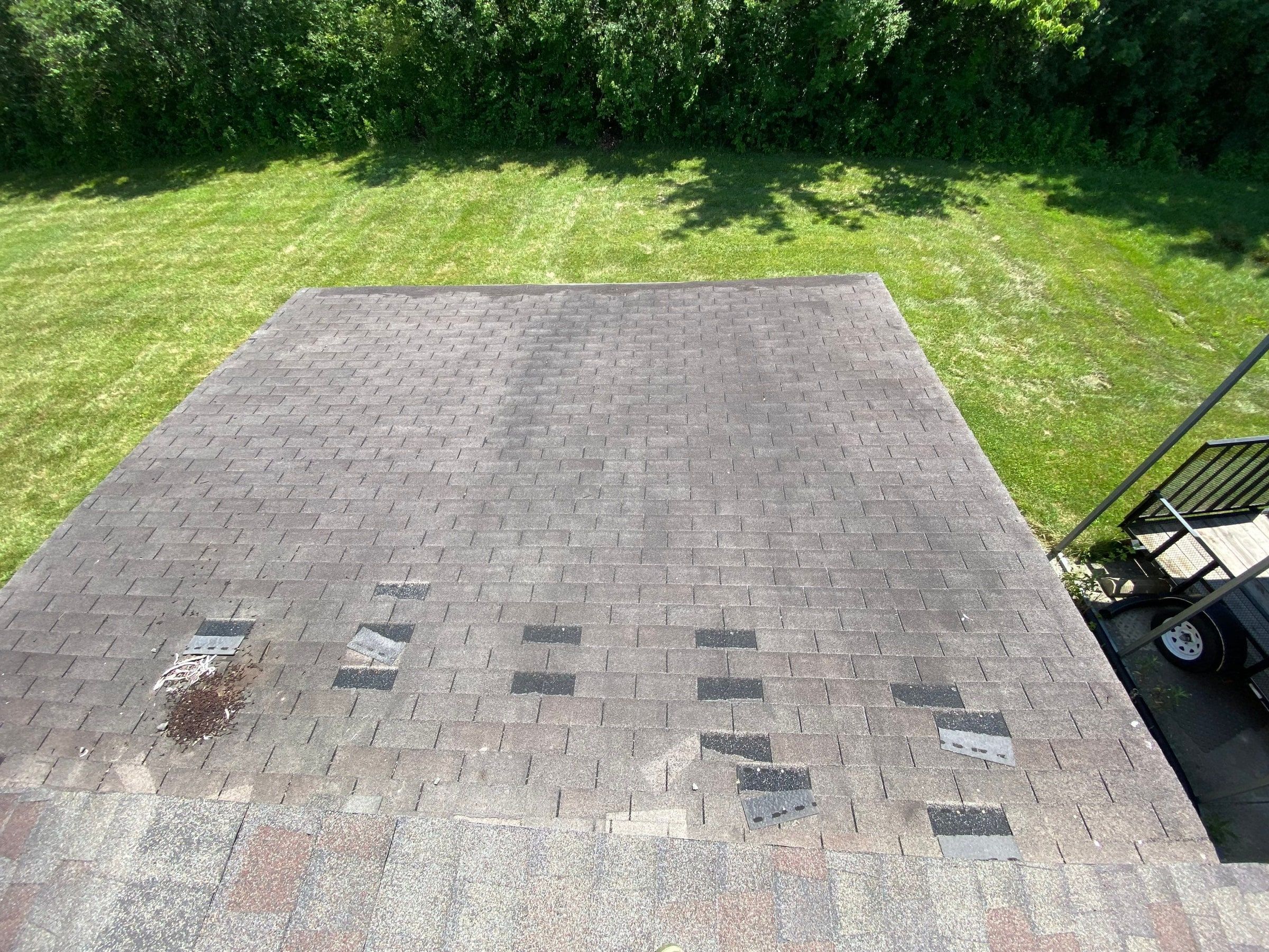 Missing shingle tabs across a garage roof after a wind storm, Yellow Springs, Ohio.