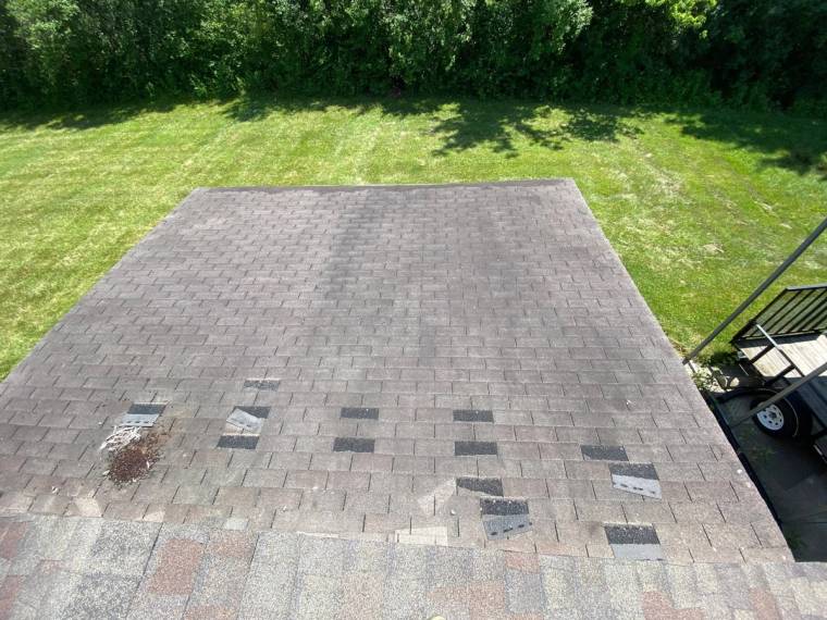 Missing shingle tabs across a garage roof after a wind storm, Yellow Springs, Ohio.