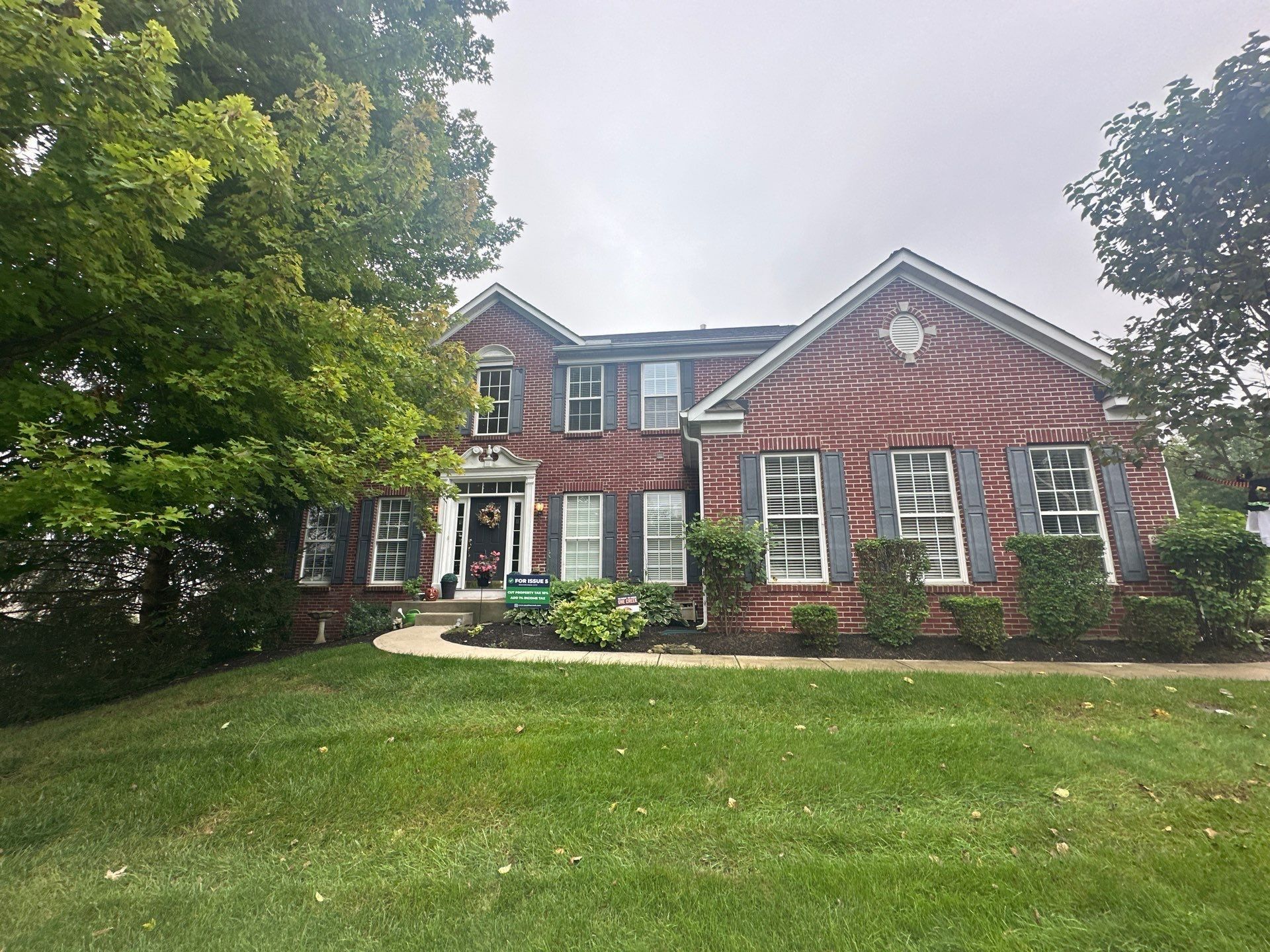 The brick front of the two-story house from the front lawn, before the new roof, Beavercreek, Ohio.