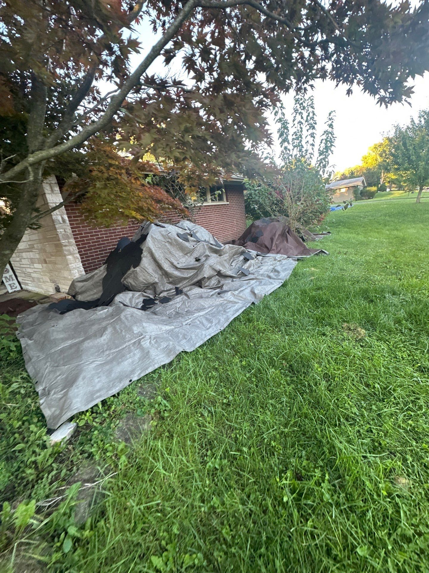 A gray tarp over the bed under the front windows, Kettering, Ohio.