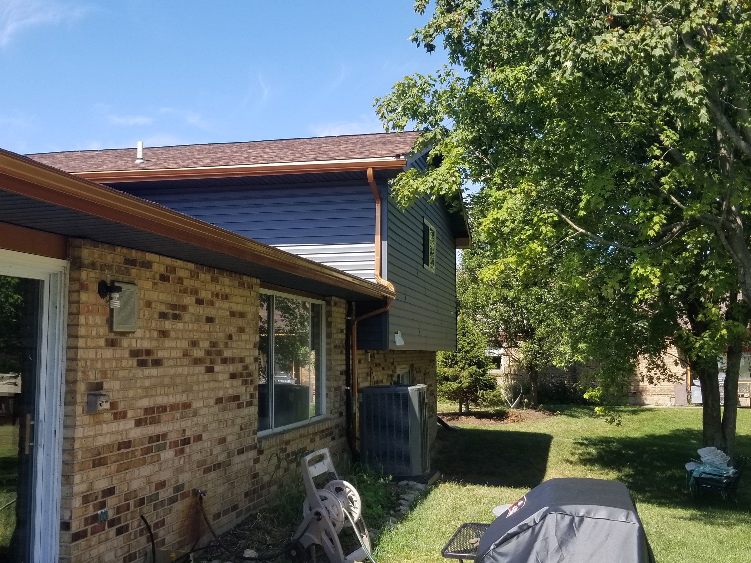 Blue-gray siding and a copper-colored downspout at the back corner, Beavercreek, Ohio.