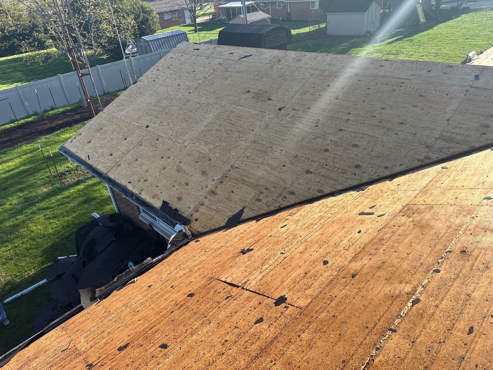Old shingles stripped away exposing the wood deck along the eave, Beavercreek, Ohio.