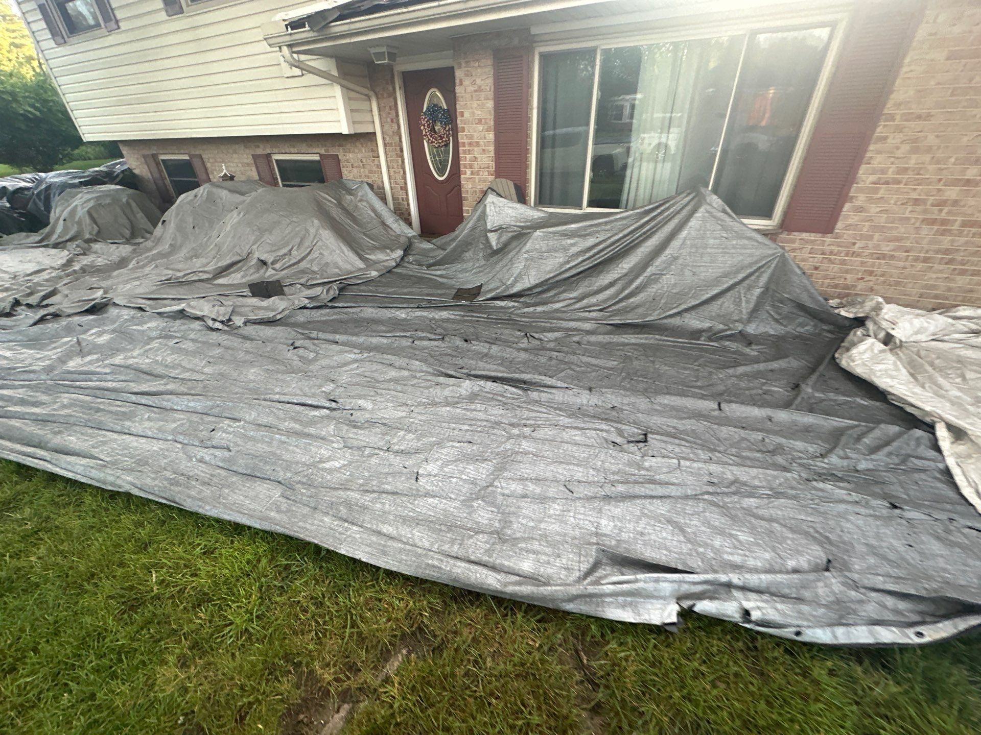 Gray tarps draped over the front shrubs below the windows, Dayton, Ohio.