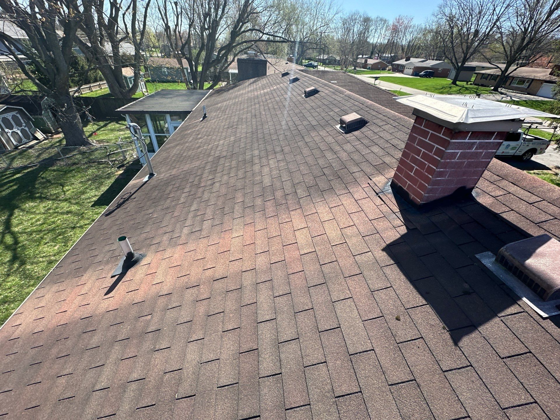 Long rear slope with the brick chimney and several box vents before tear off, Beavercreek, Ohio.