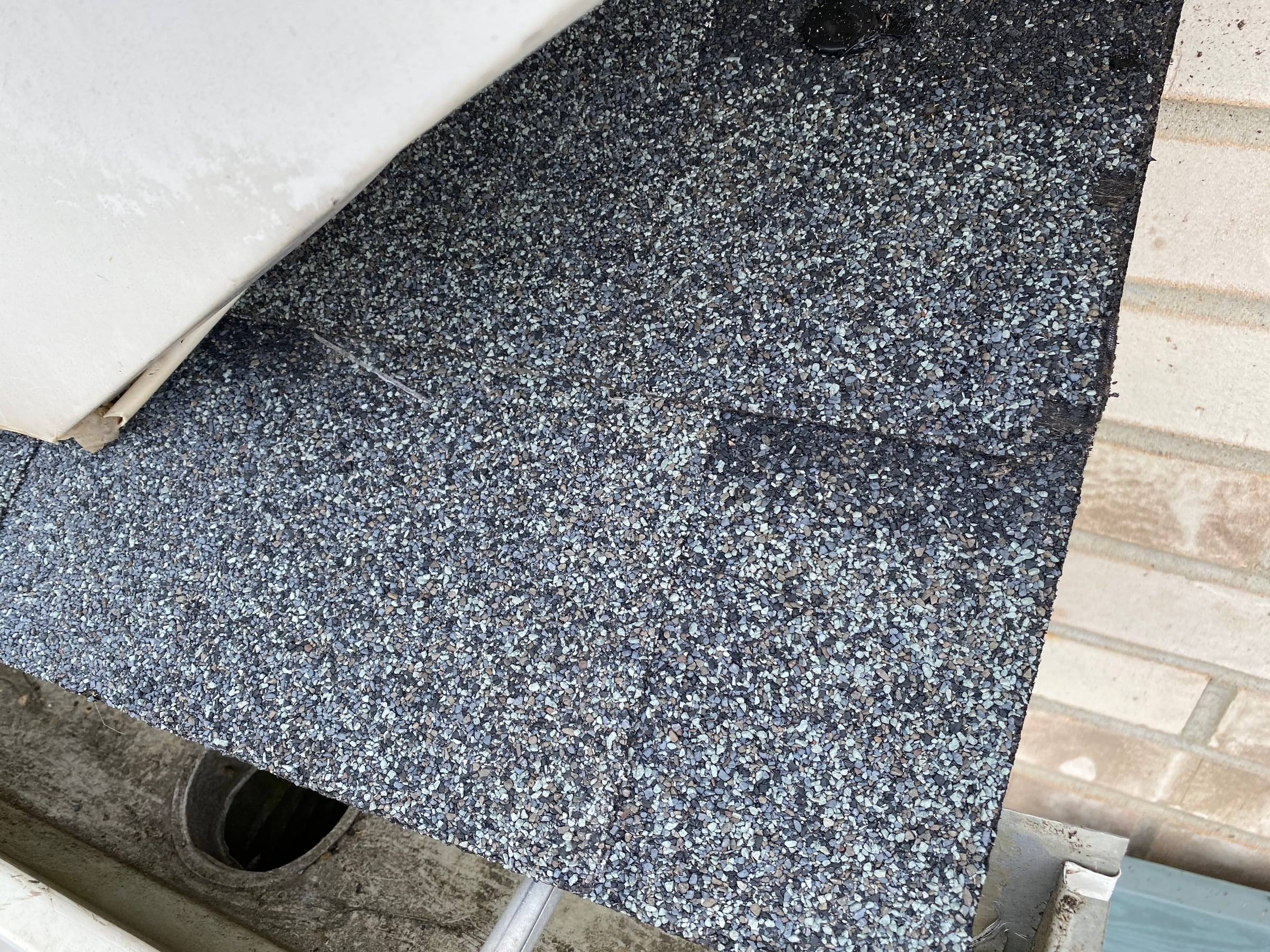 Shingles cut in above the downspout outlet