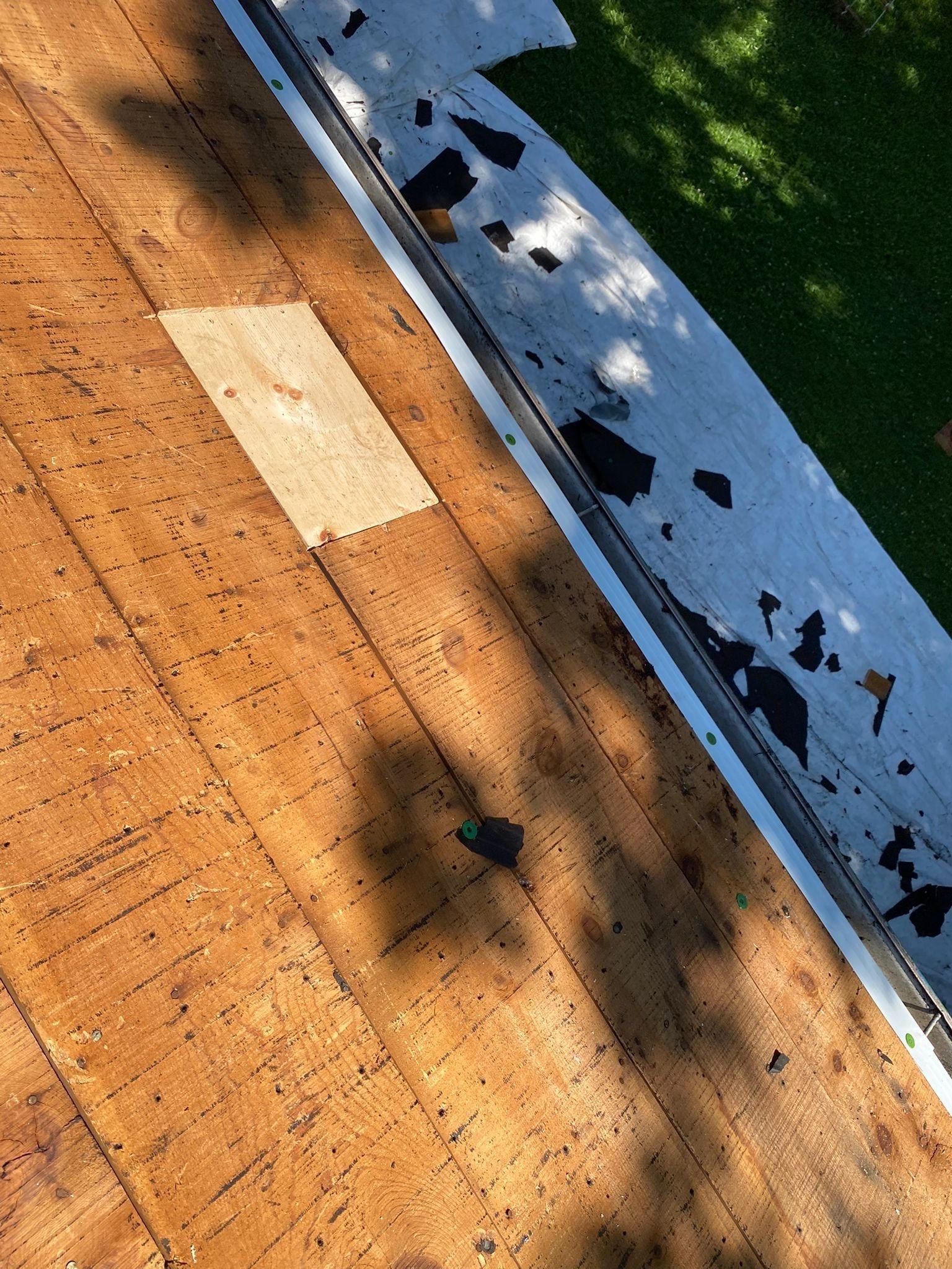 White metal drip edge fastened along the eave beside a new deck patch, Beavercreek, Ohio.