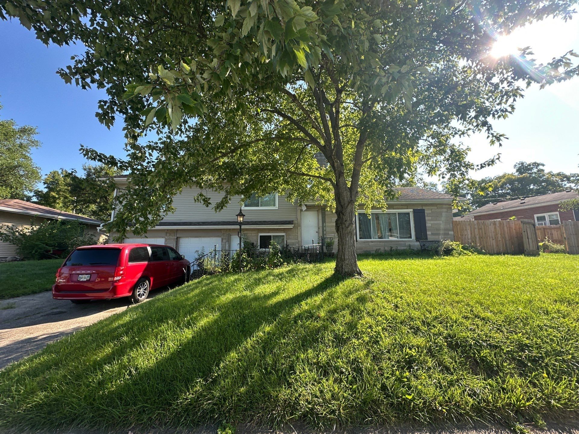 The house and front lawn under a shade tree, with a van in the drive, Fairborn, Ohio.