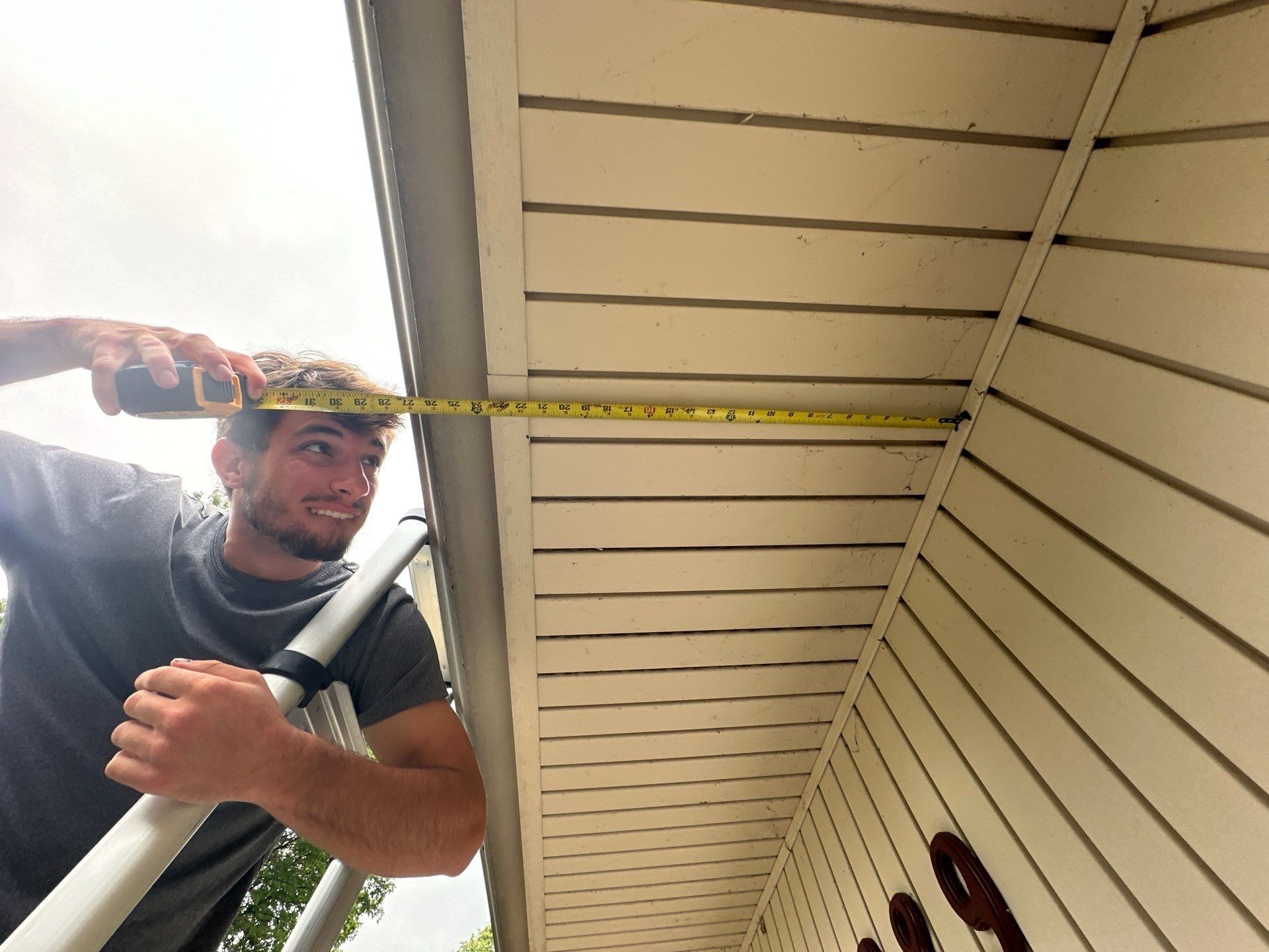 Tape measure stretched across the soffit to size the roof overhang, Beavercreek, Ohio.