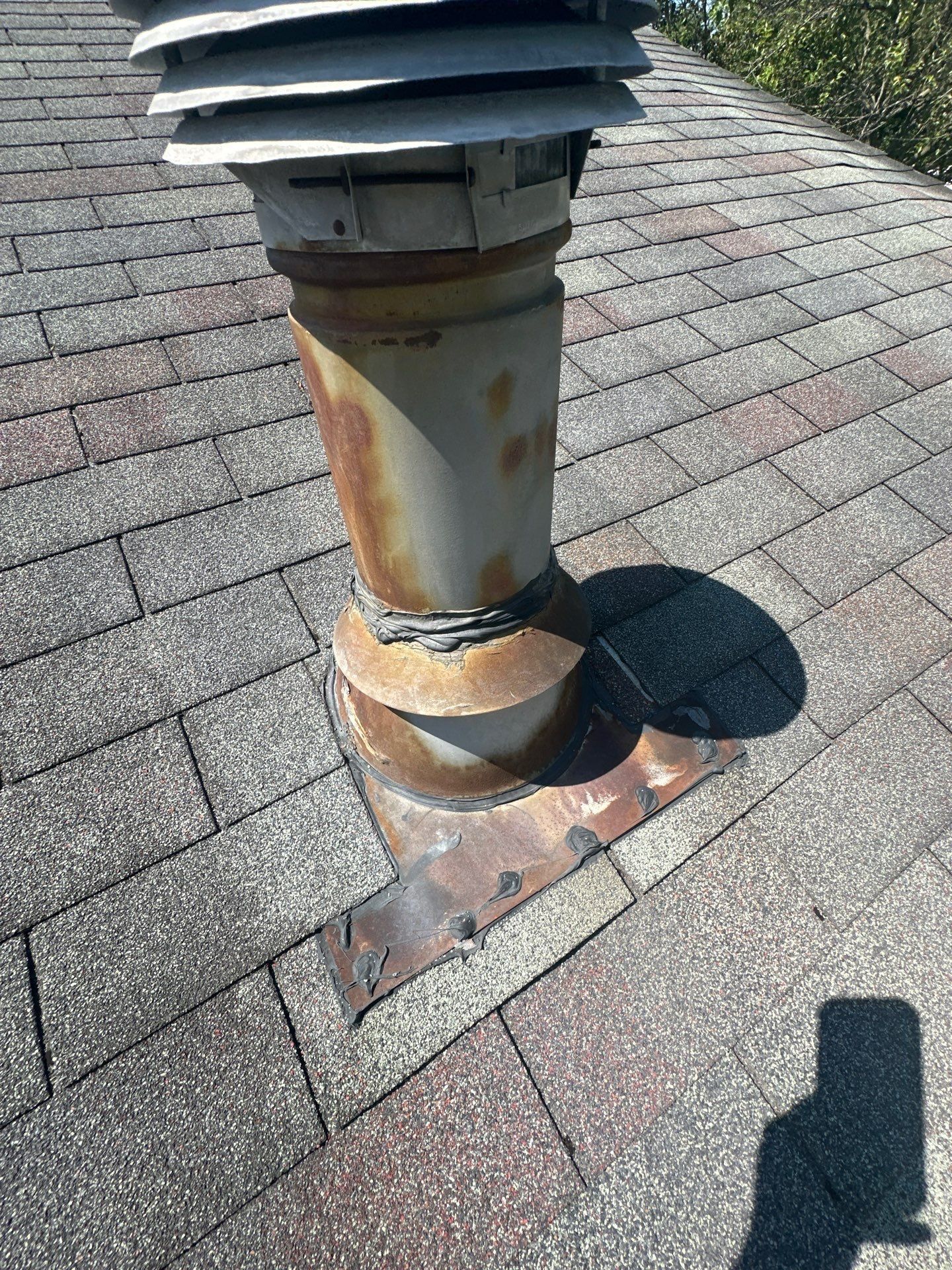 A rusted vent stack with worn flashing on the old roof, West Carrollton, Ohio.