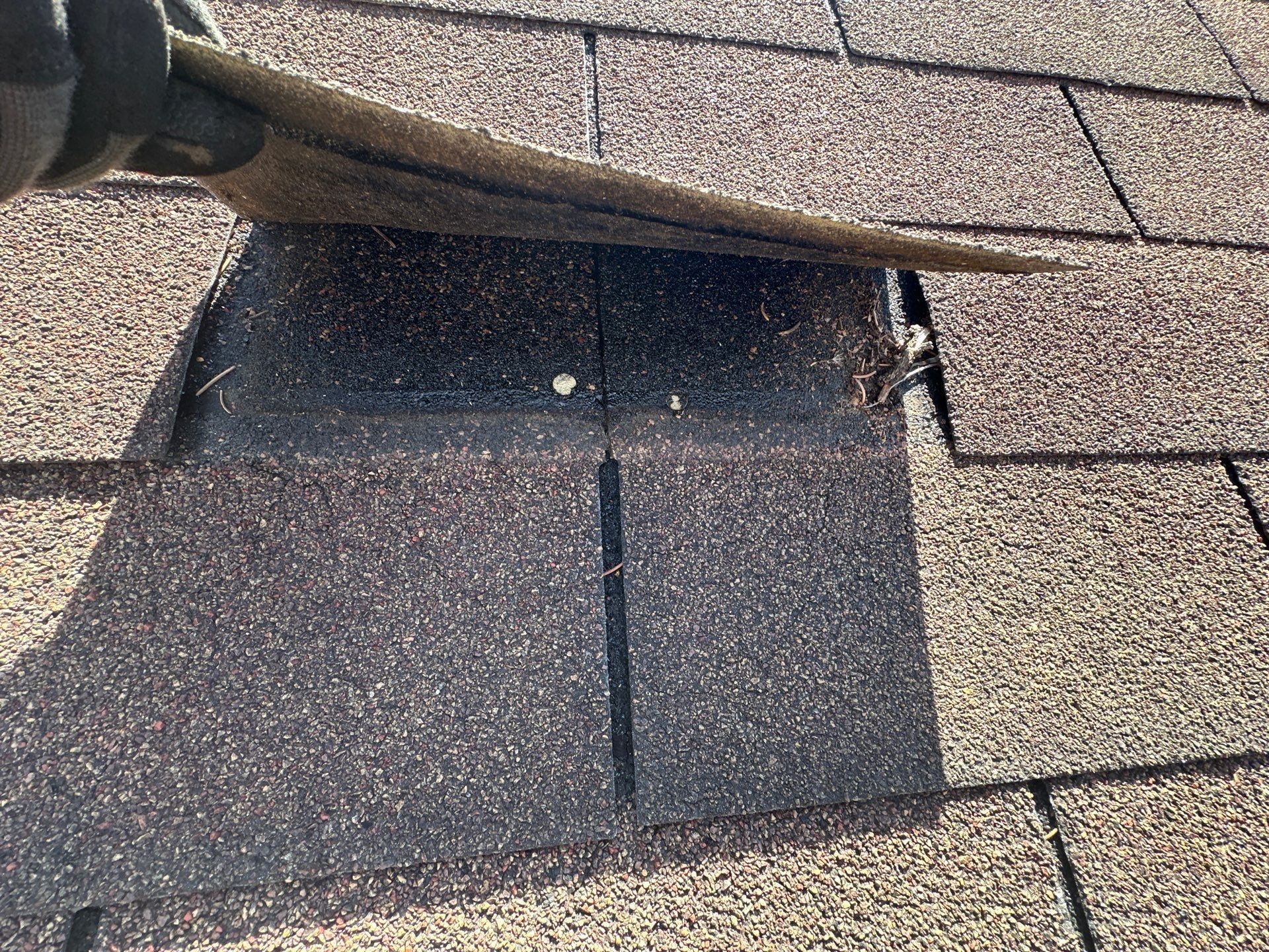 Unsealed shingle lifted back easily, showing wind damage underneath, Beavercreek, Ohio.
