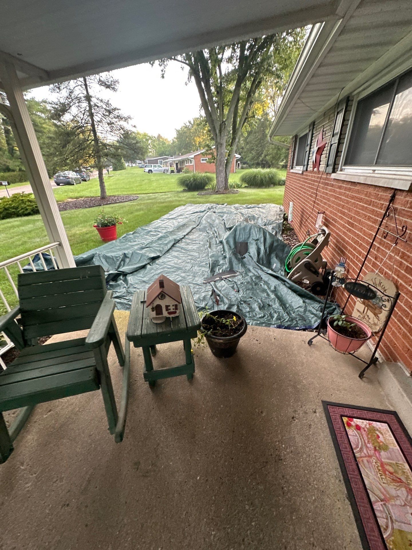 Green tarps, porch chairs and birdhouse