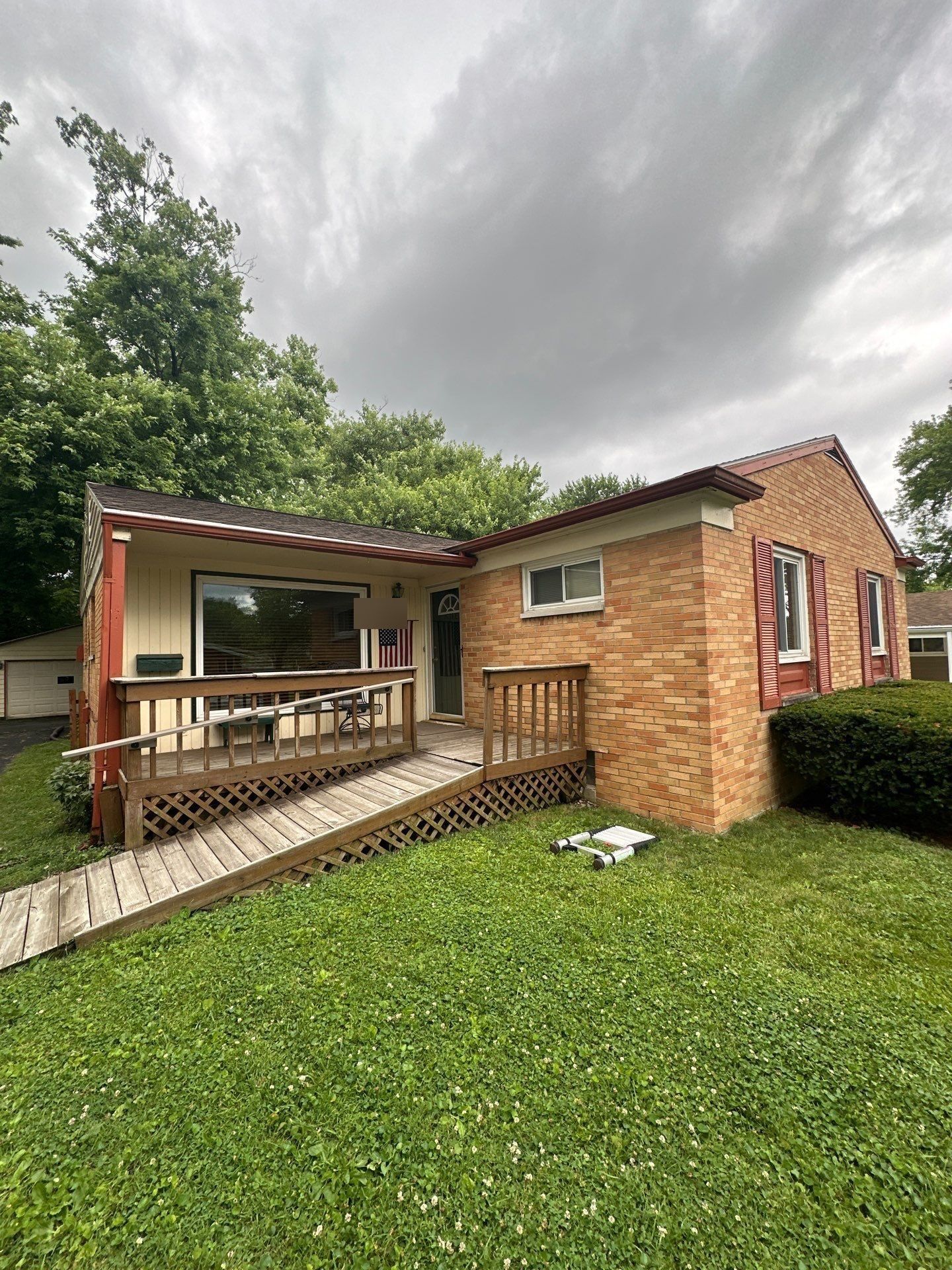 Brick ranch house in Kettering, Ohio, with its covered front porch and the old gutters, before the work.