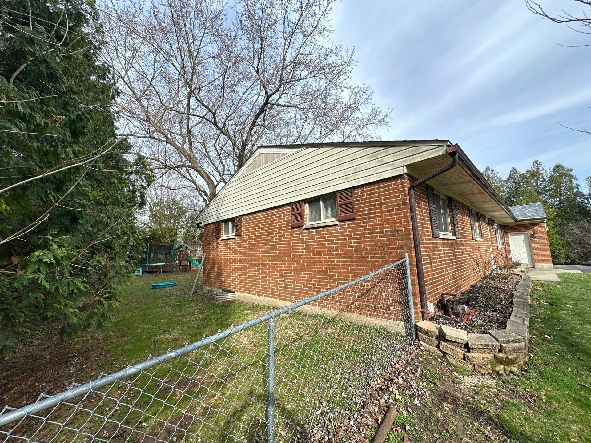 Brick gable end and chain-link fence