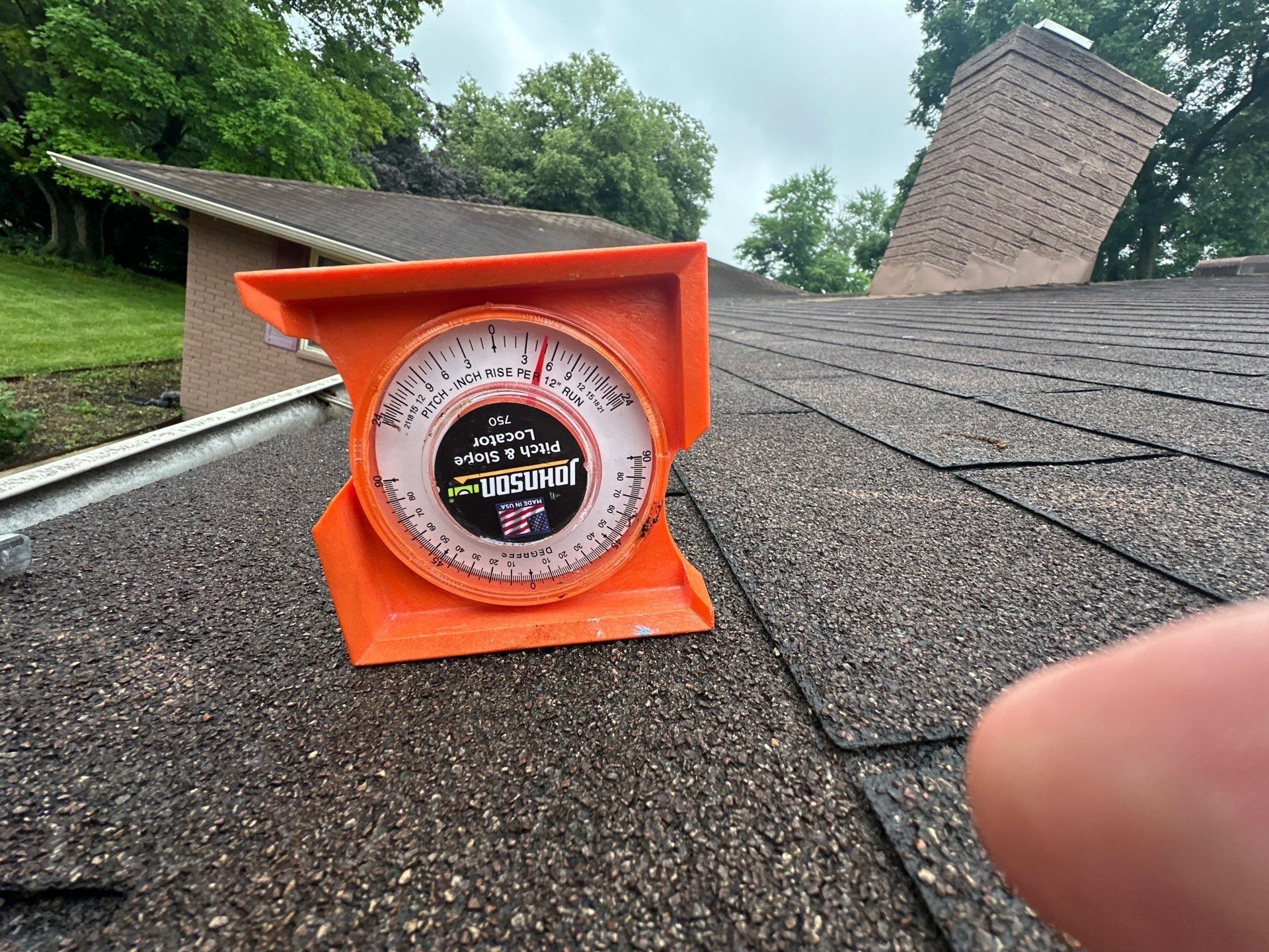 Pitch gauge set on the old shingles to read the roof slope, Beavercreek, Ohio.