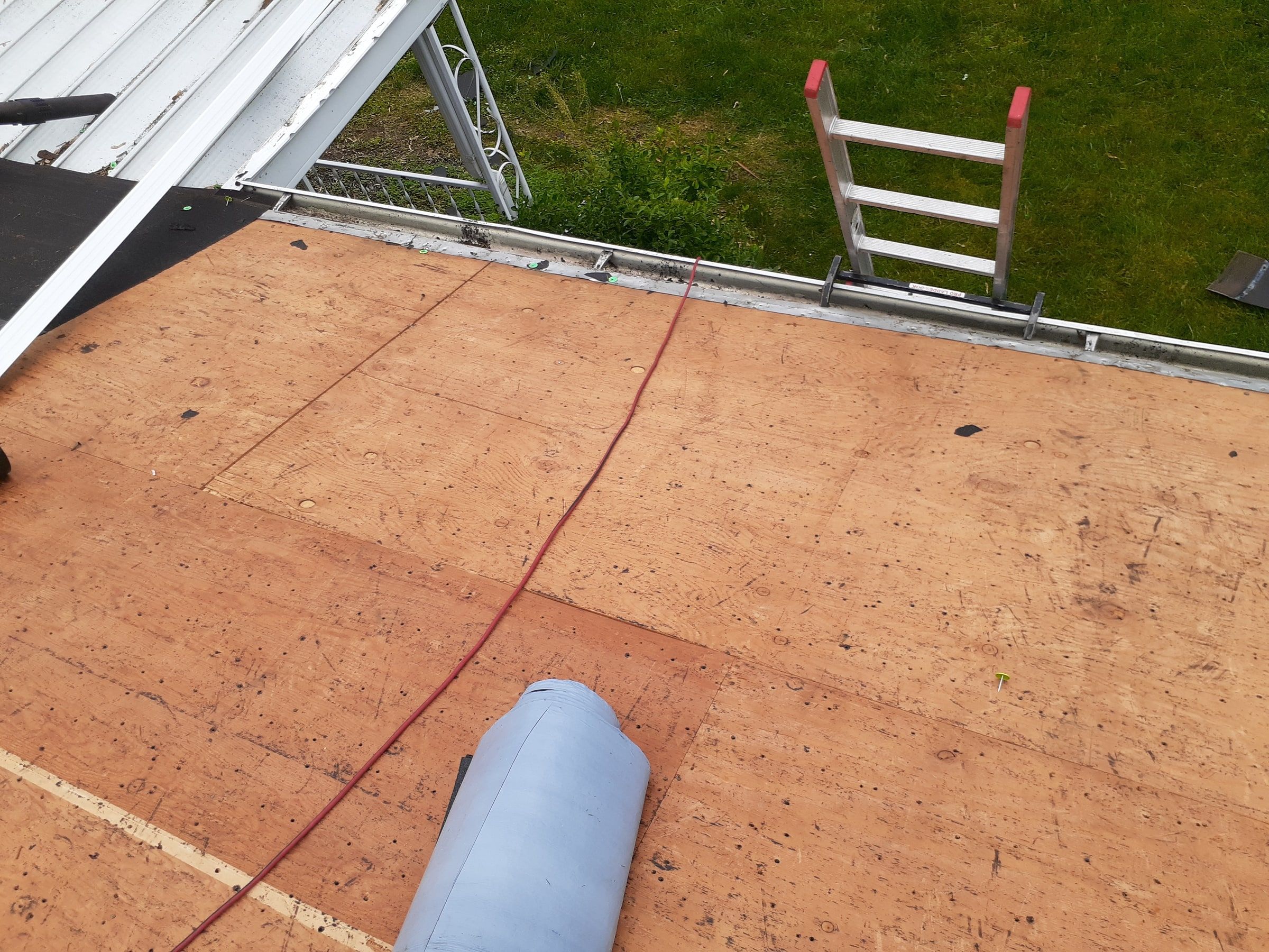 The bare deck at the eave with a roll of underlayment ready, Huber Heights, Ohio.