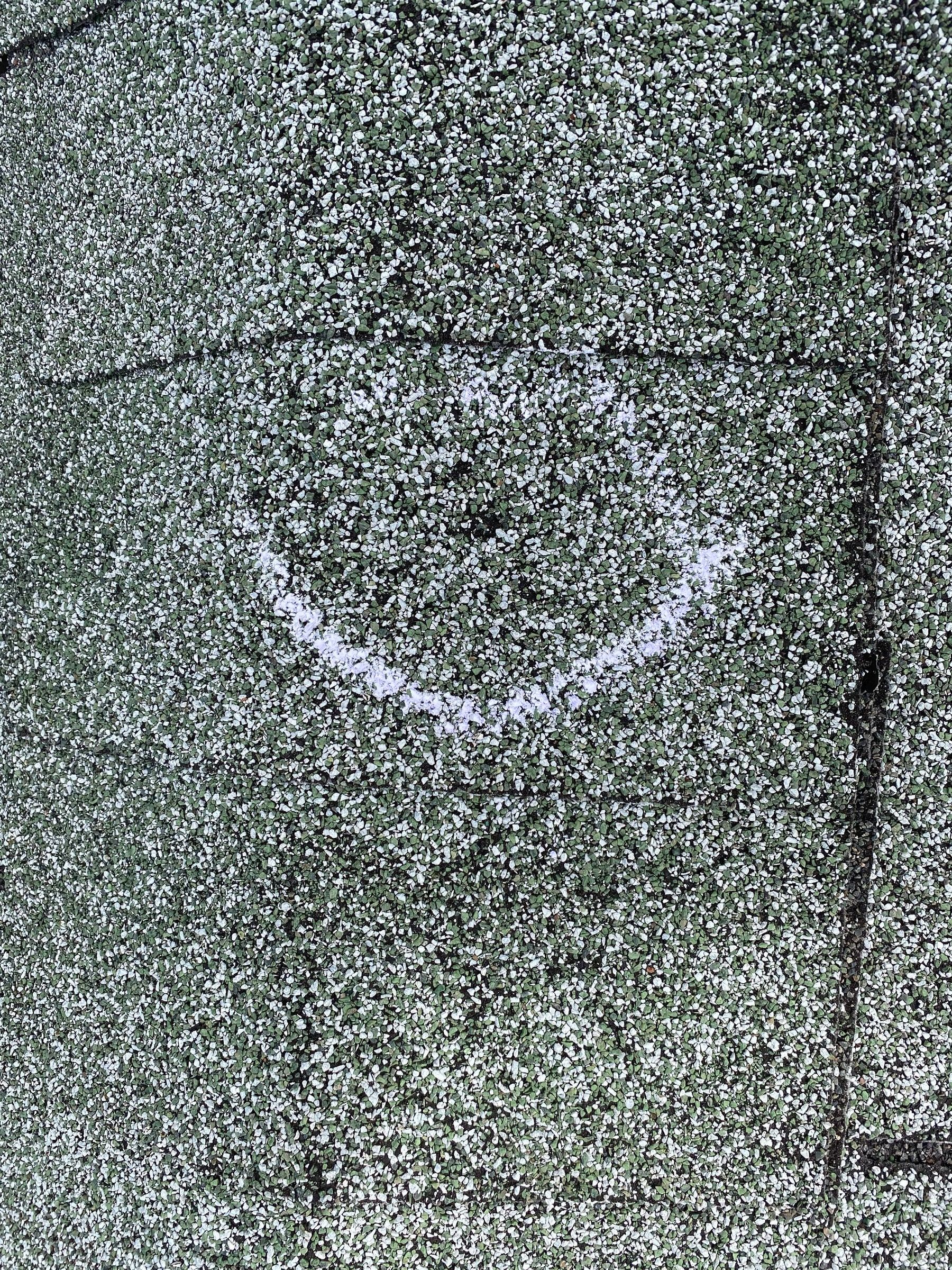 A hail hit circled in chalk low on a weathered shingle, Kettering, Ohio.