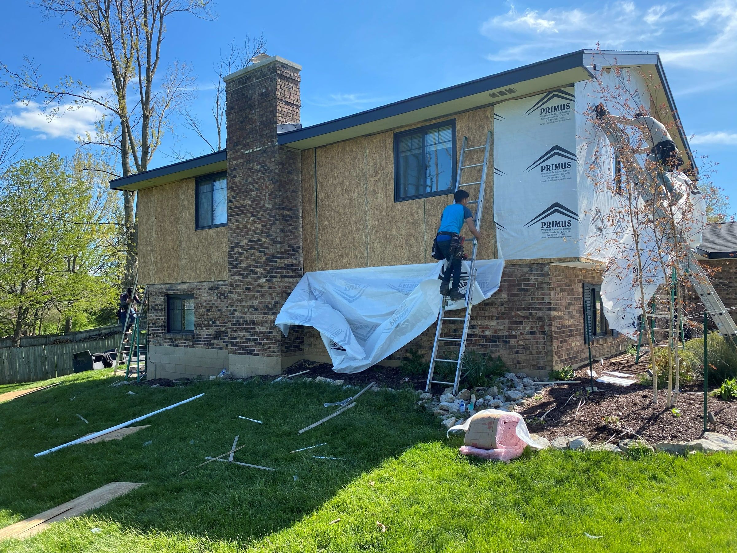 House wrap going up the chimney side, with the crew on ladders, Beavercreek, Ohio.
