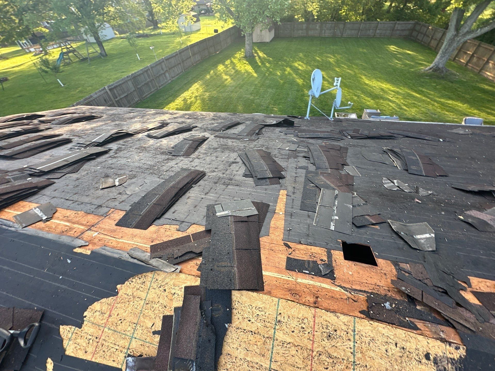 Old underlayment and bare deck showing as the tear-off moves down the slope, Beavercreek, Ohio.