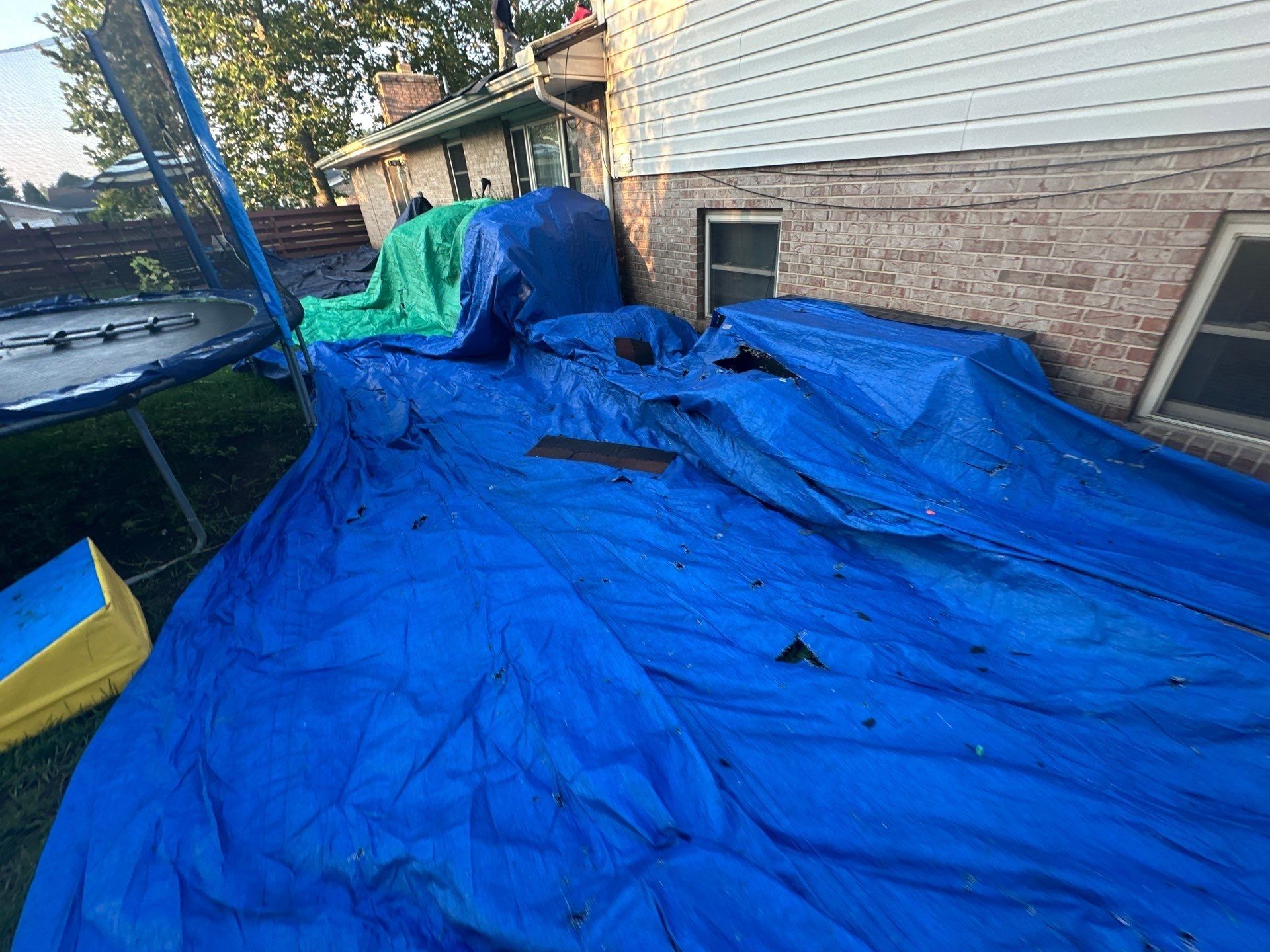Blue tarps over the back beds catching pieces of old shingle, Dayton, Ohio.