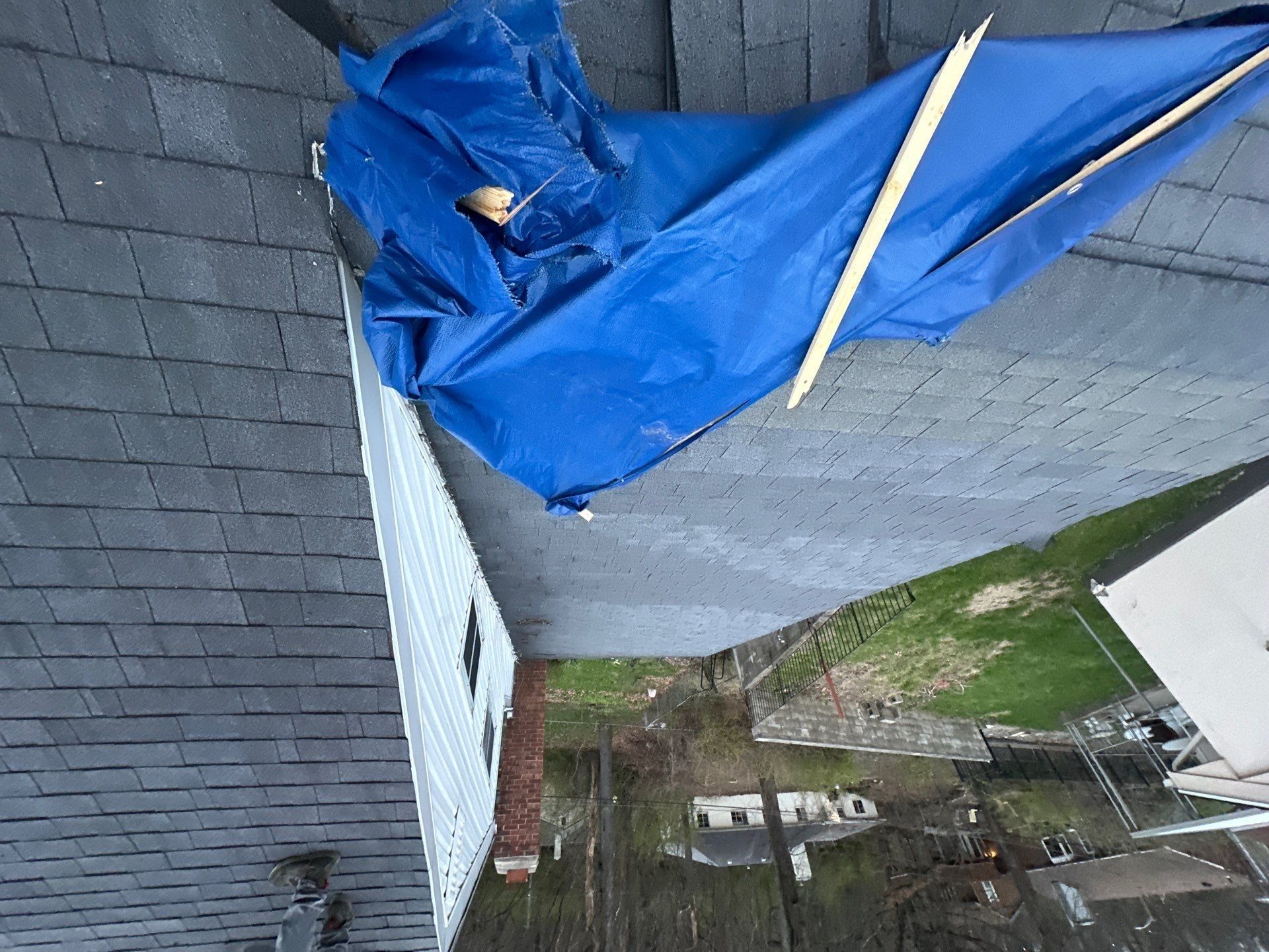 Blue tarp against the white siding