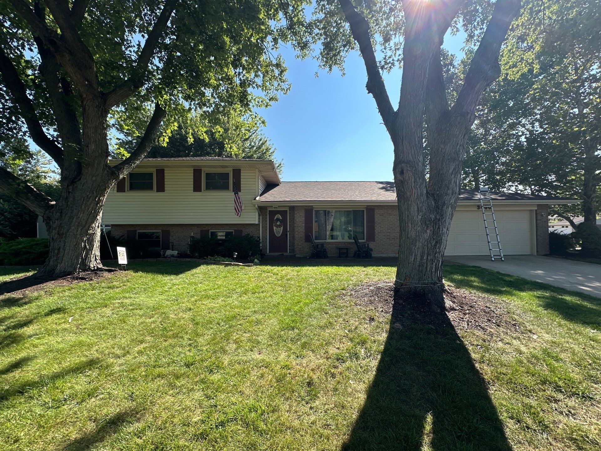 The finished house roof from the front lawn, under two shade trees, Dayton, Ohio.