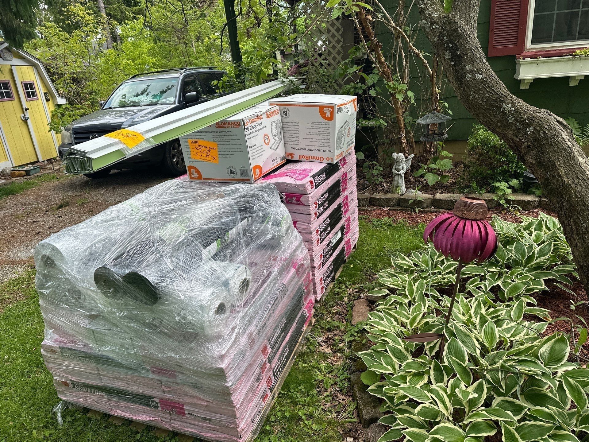A wrapped pallet of Duration shingles and supplies in the side yard, Springfield, Ohio.