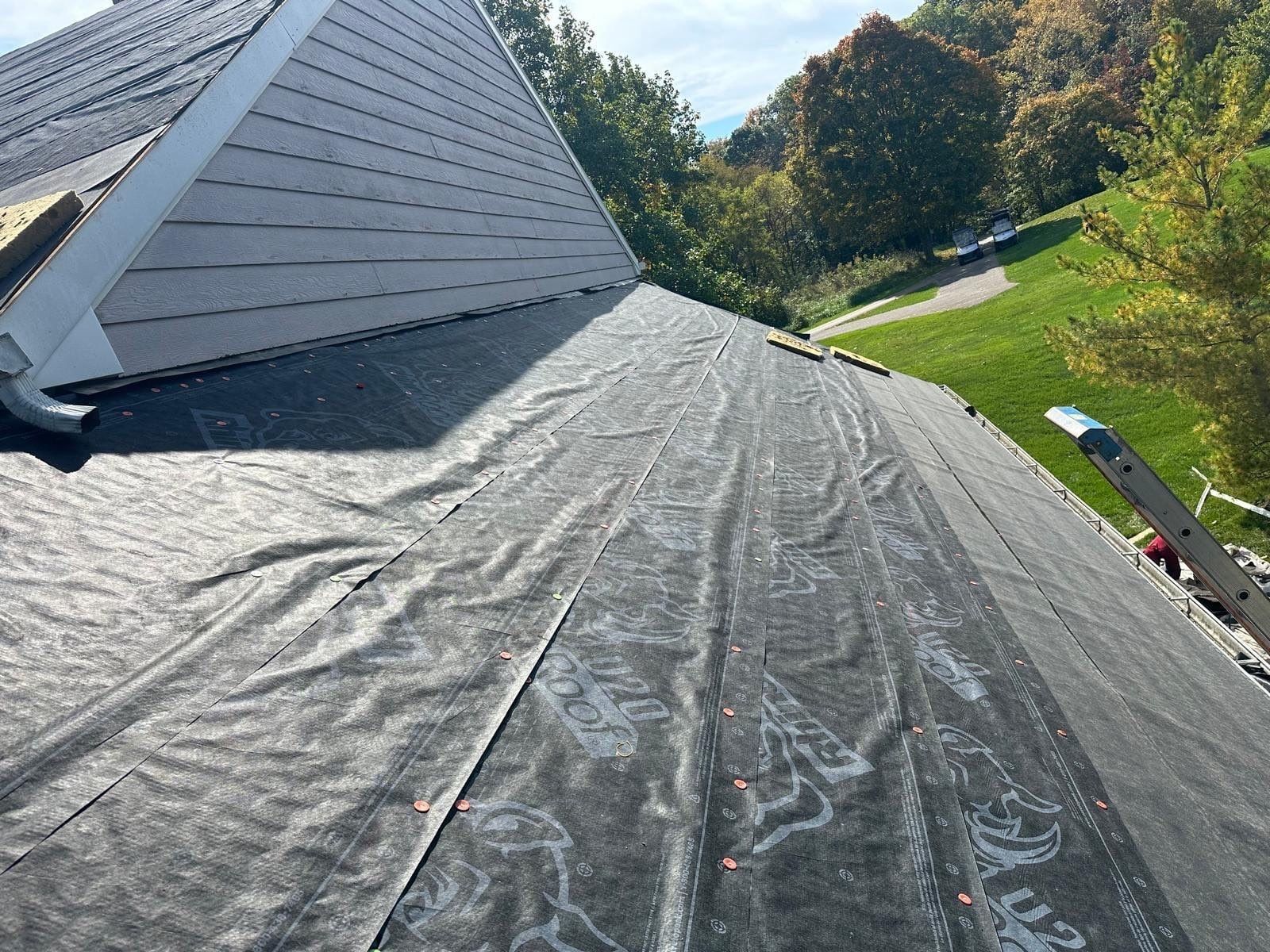 Underlayment turned up against the siding where a lower roof meets the wall, Beavercreek, Ohio.