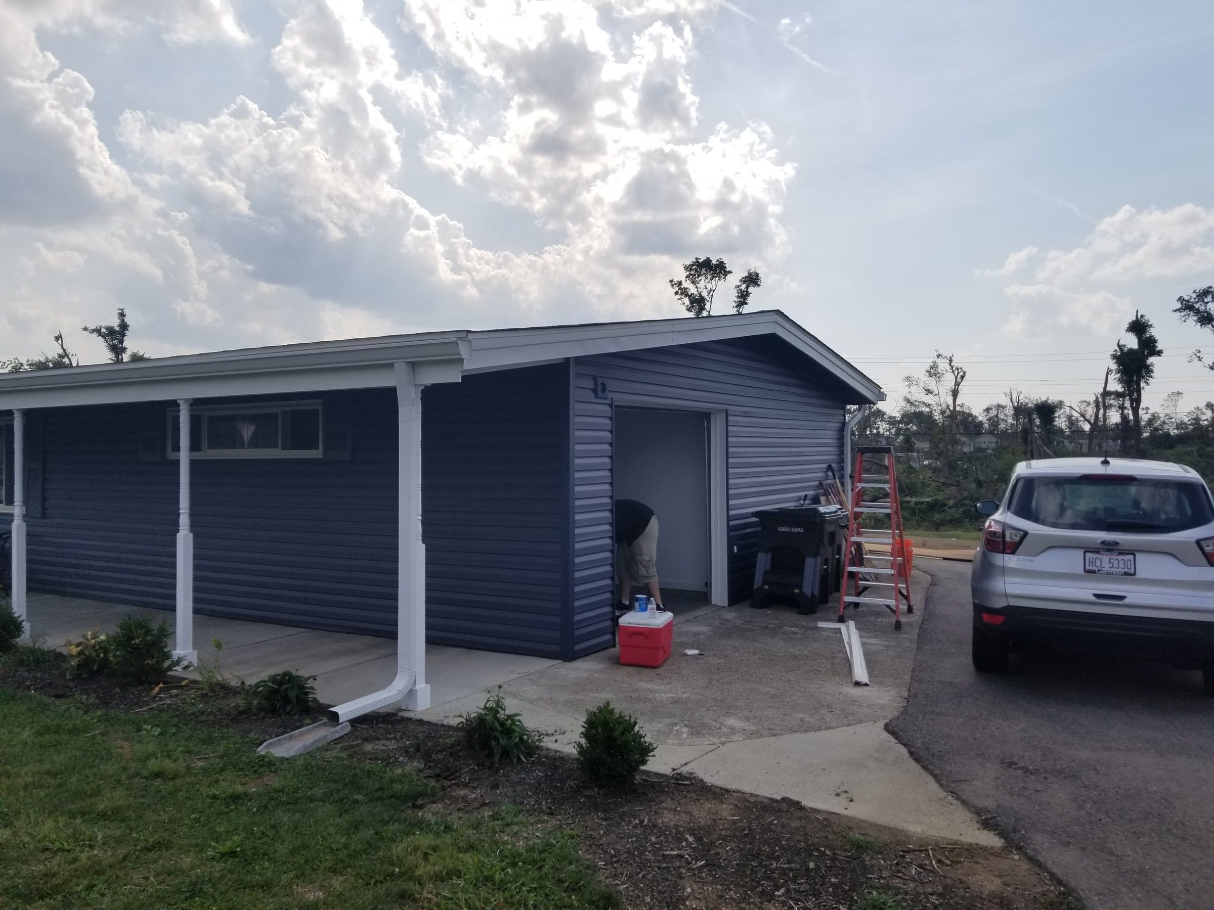 The garage end in new blue siding with white trim and a new downspout, Beavercreek, Ohio.