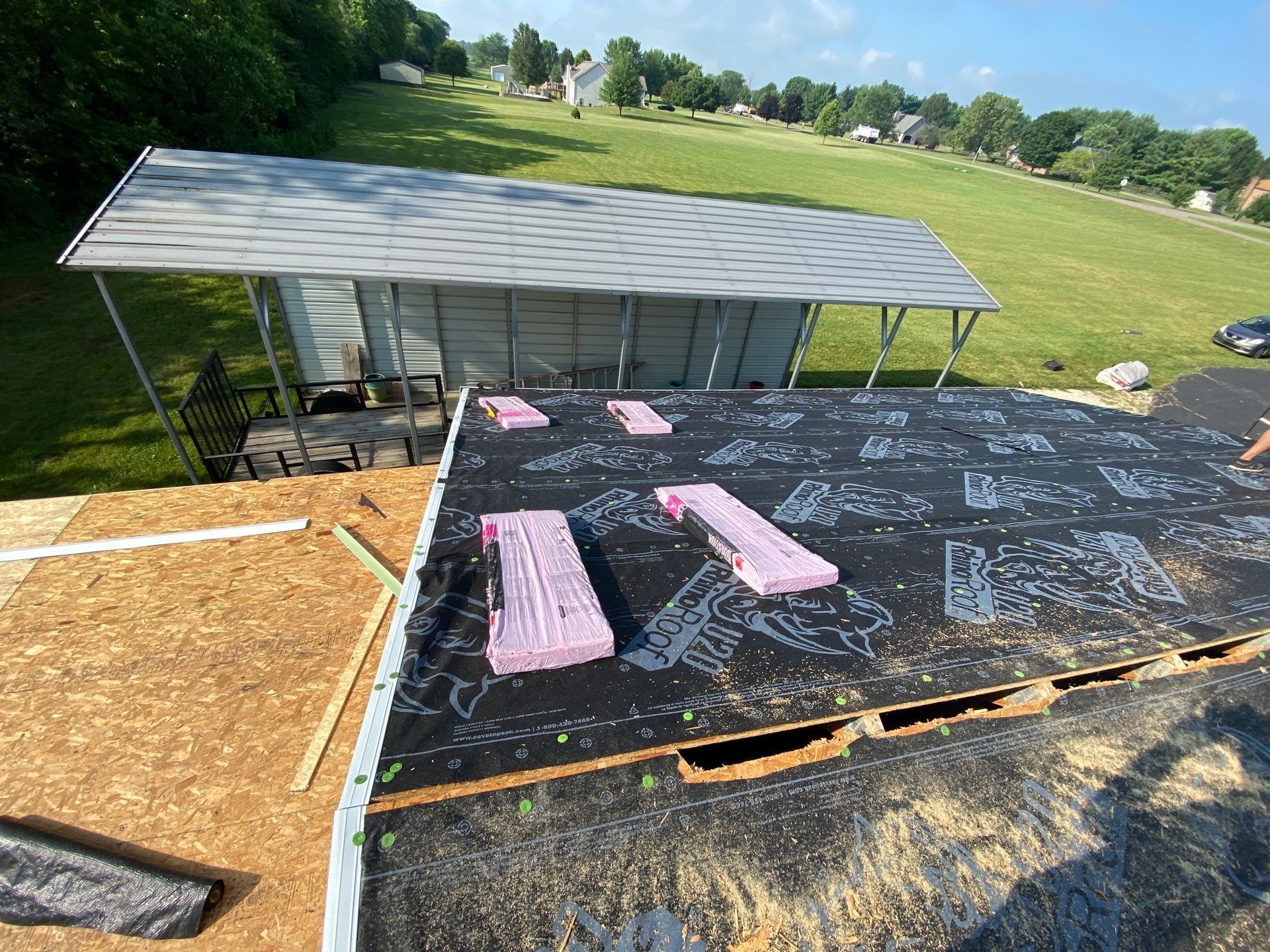 Detached garage roof under new underlayment with shingle bundles staged, Yellow Springs, Ohio.