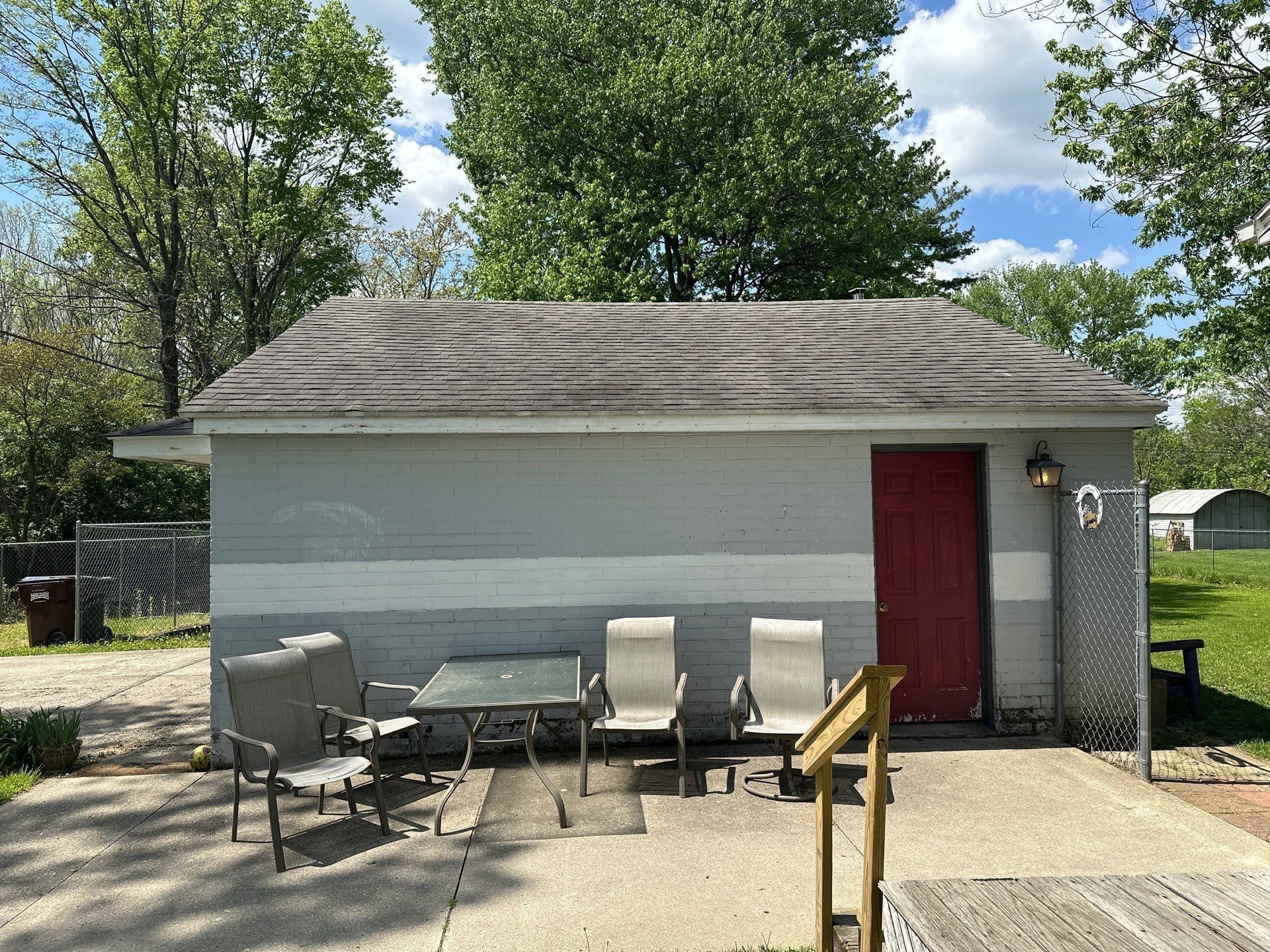 Painted brick outbuilding and patio chairs