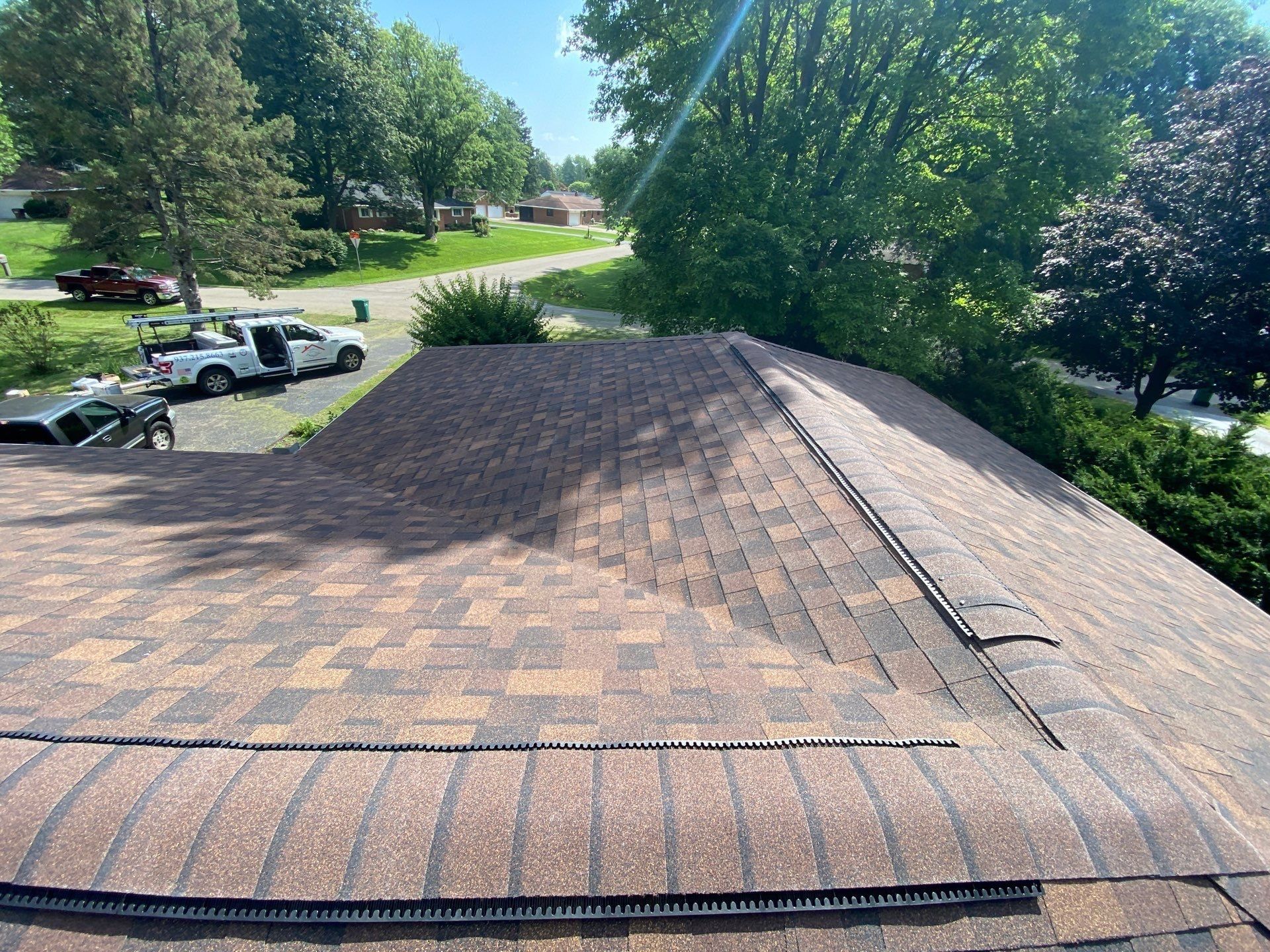 Finished front slopes with ridge vent and hip caps toward the street, Beavercreek, Ohio.