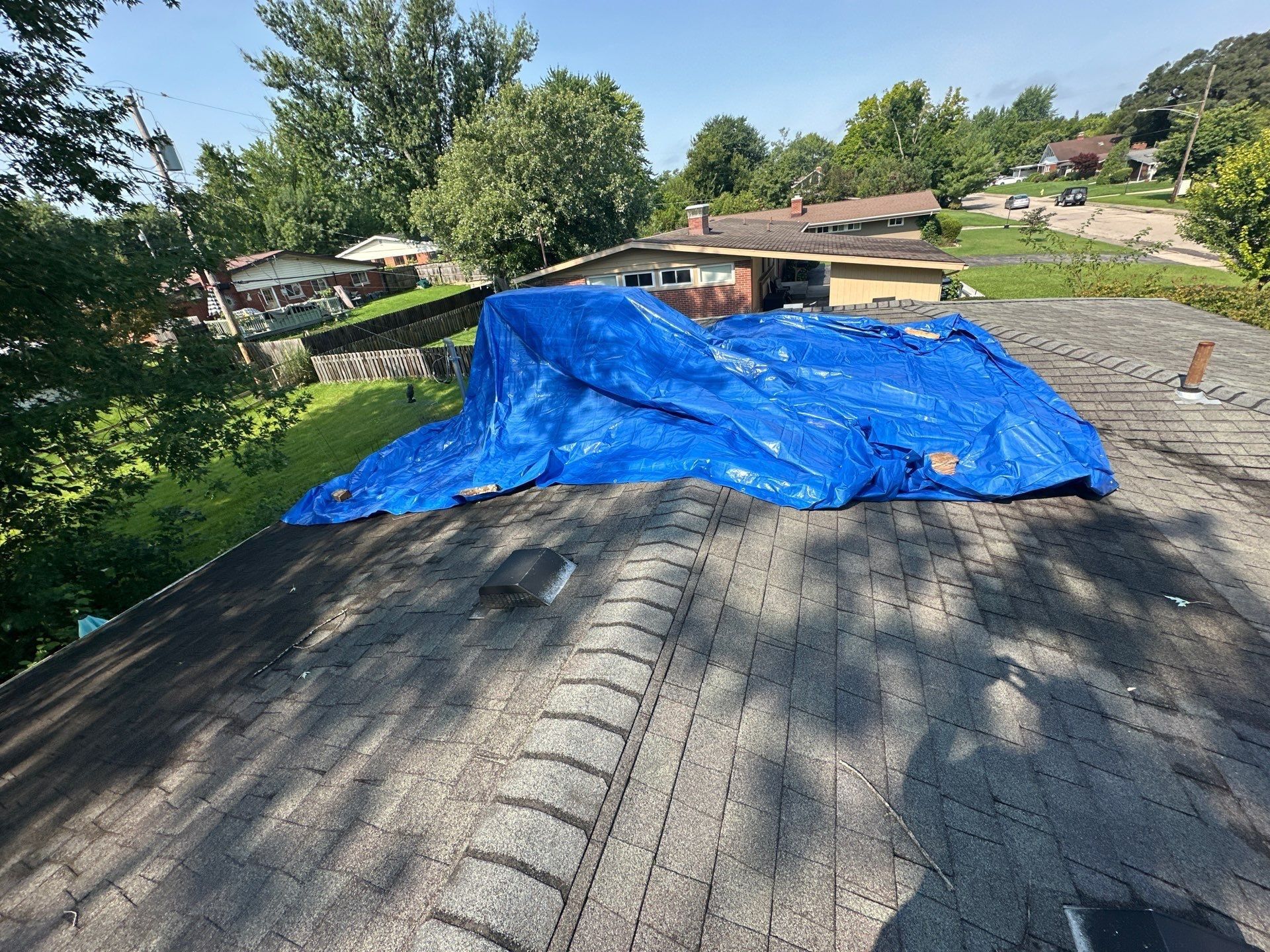 A blue tarp over part of the old roof, held down with boards, Kettering, Ohio.