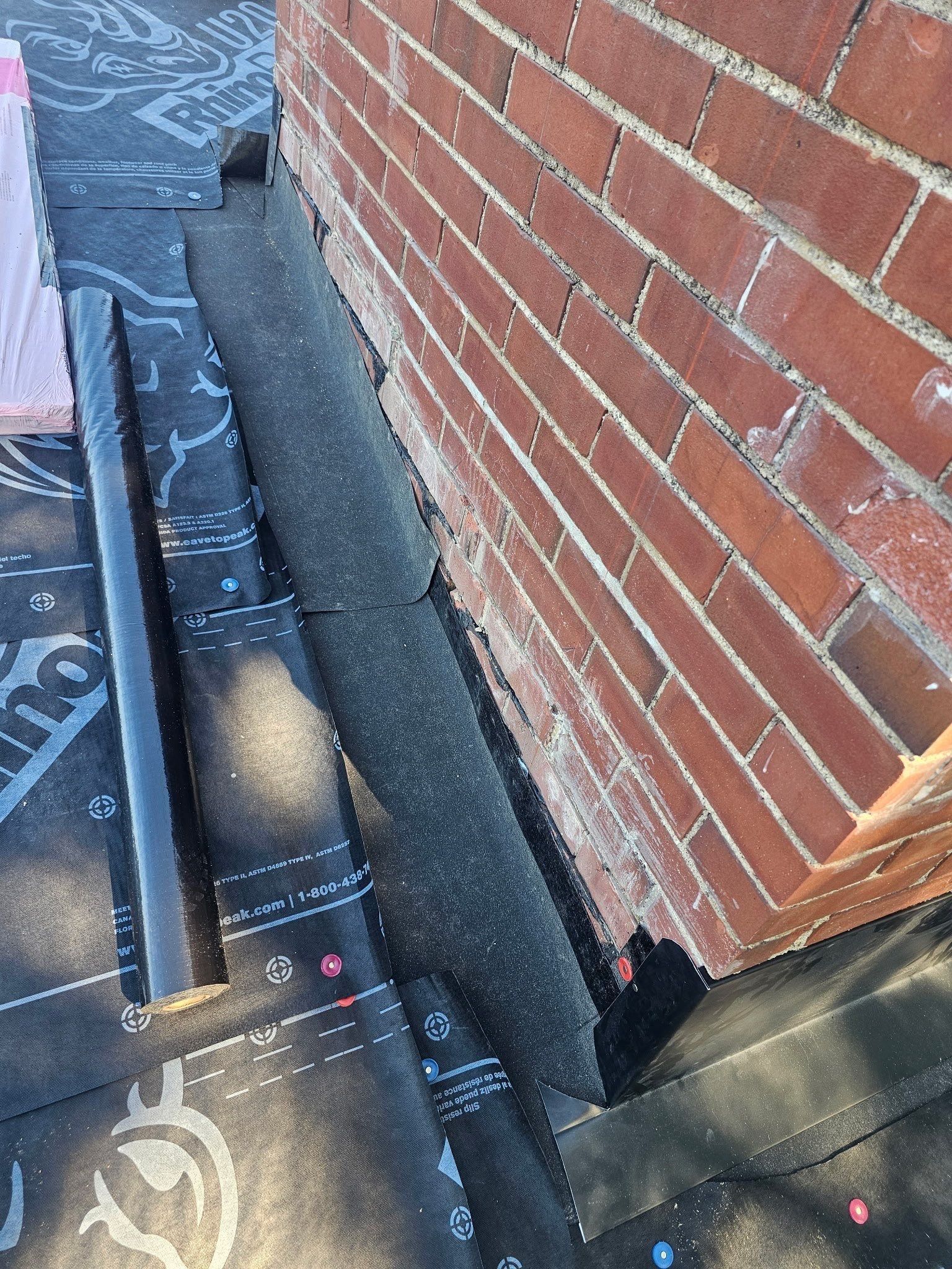 Black membrane turned up the side of the brick chimney over the underlayment, Kettering, Ohio.