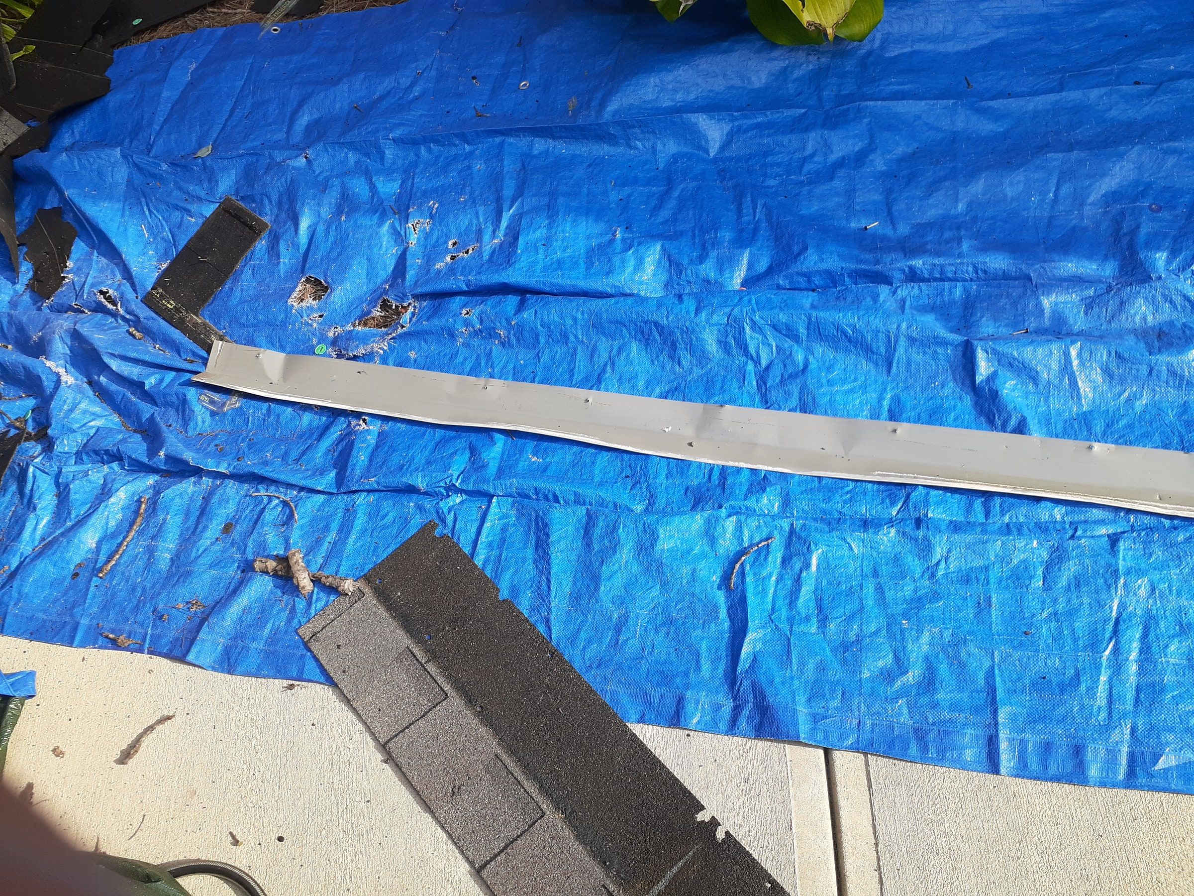 Gray edge metal run on a blue tarp