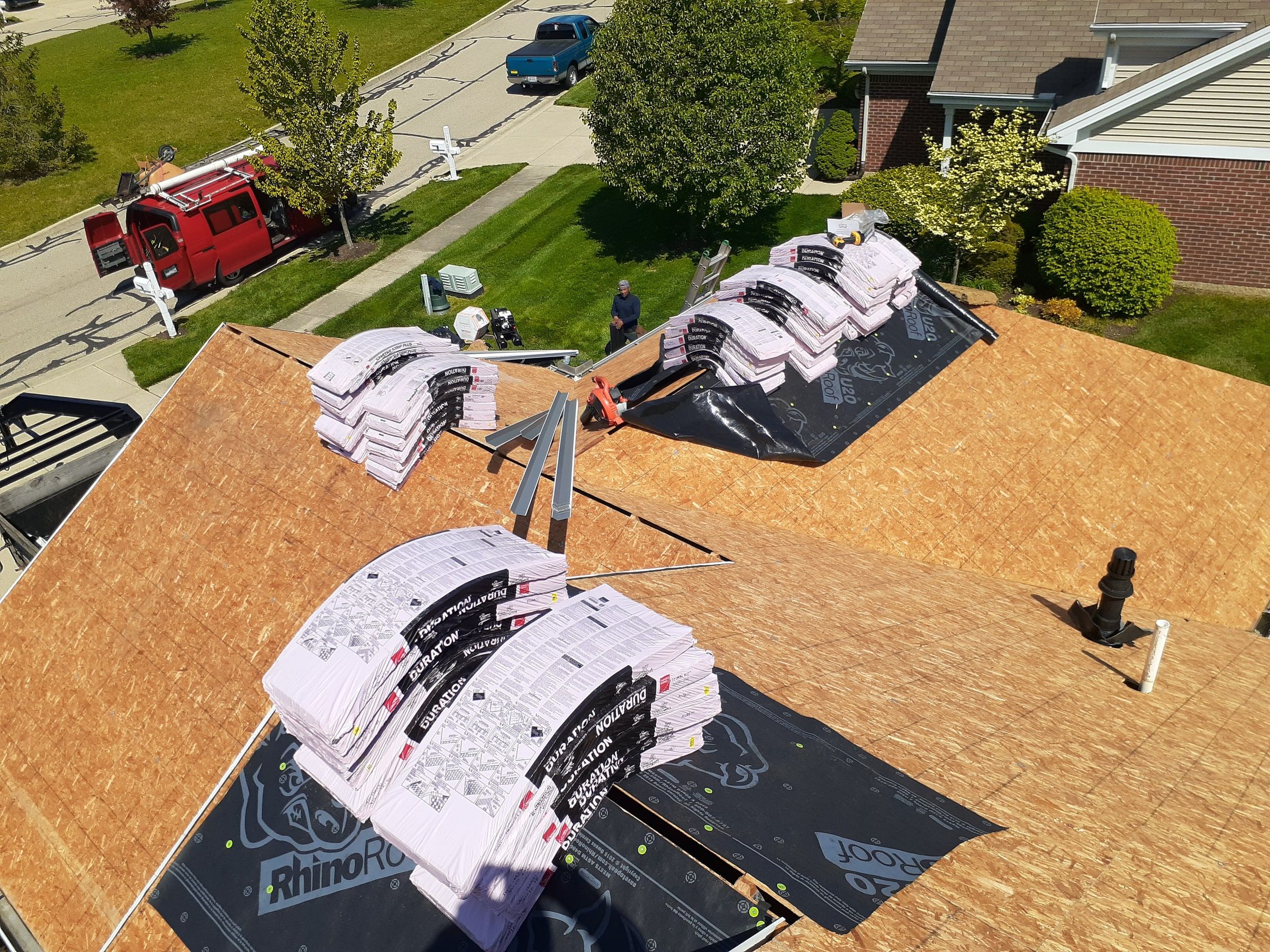 The OSB deck after tear-off, with bundles staged and the street below, Xenia, Ohio.