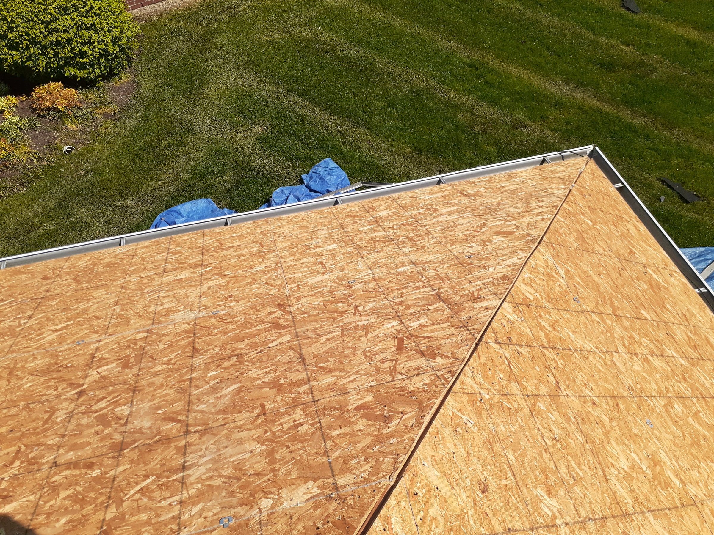Two stripped OSB slopes meeting above the lawn, Xenia, Ohio.