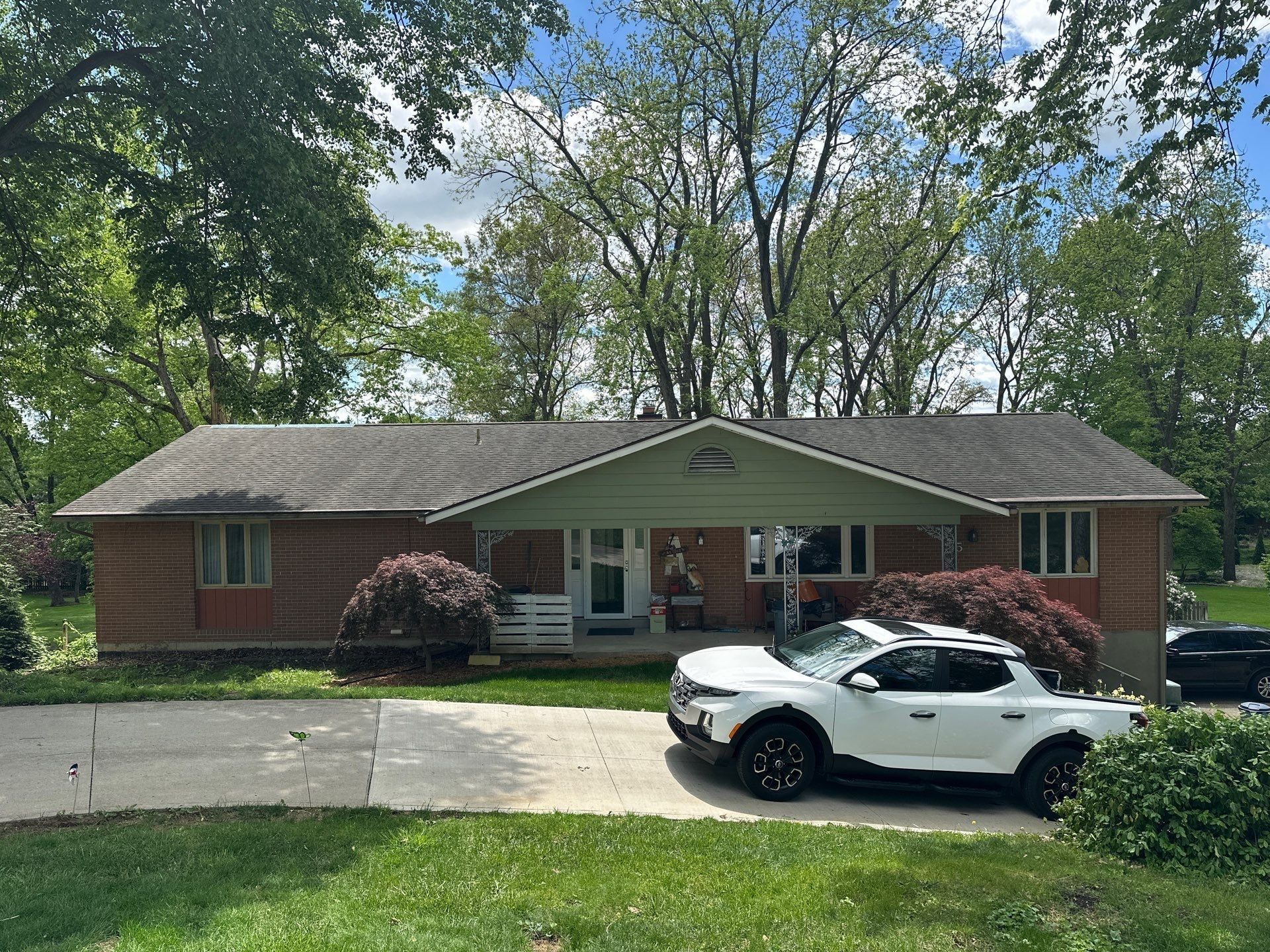 Brick ranch from the lawn, dark roof