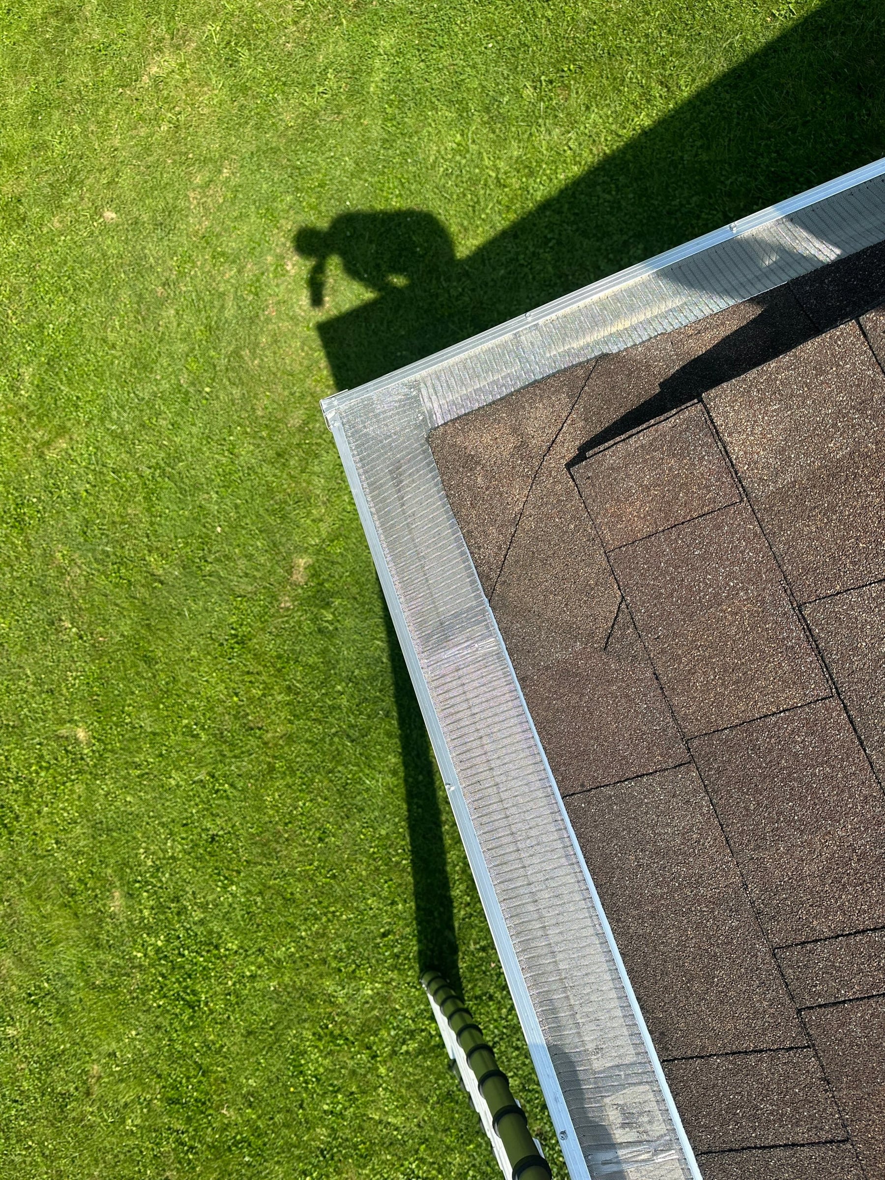 Drone photo of mesh gutter guards wrapping the corner of the roof, with the lawn below, Kettering, Ohio.