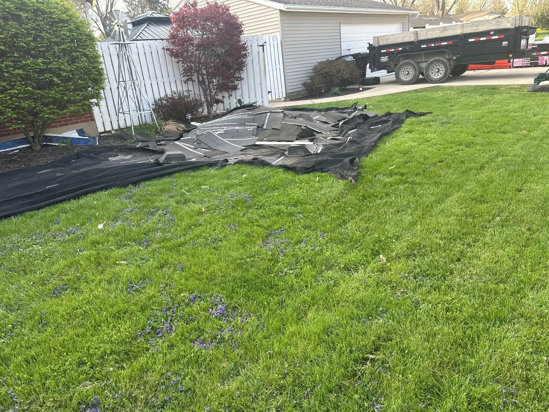 A ground tarp catching debris beside the fence, Beavercreek, Ohio.