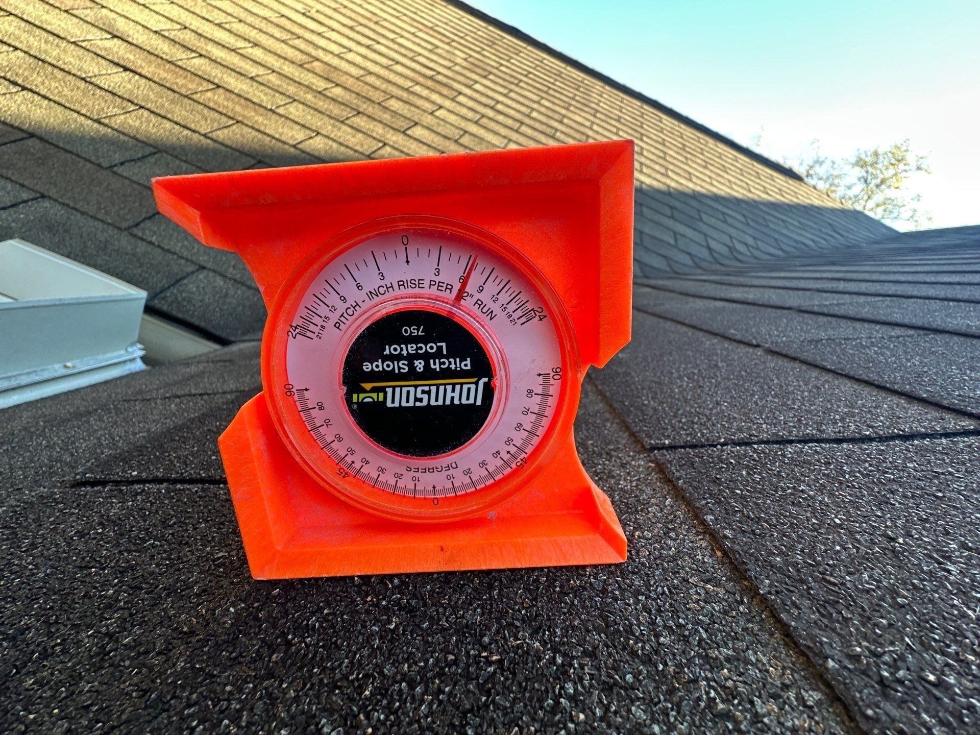 A pitch gauge set on the old shingles to check the slope of the roof, Beavercreek, Ohio.