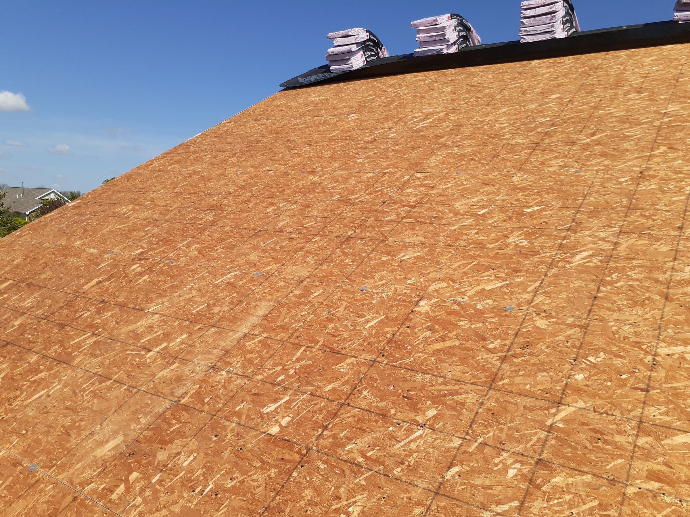 A clean OSB deck after tear-off, with bundles staged at the top, Xenia, Ohio.