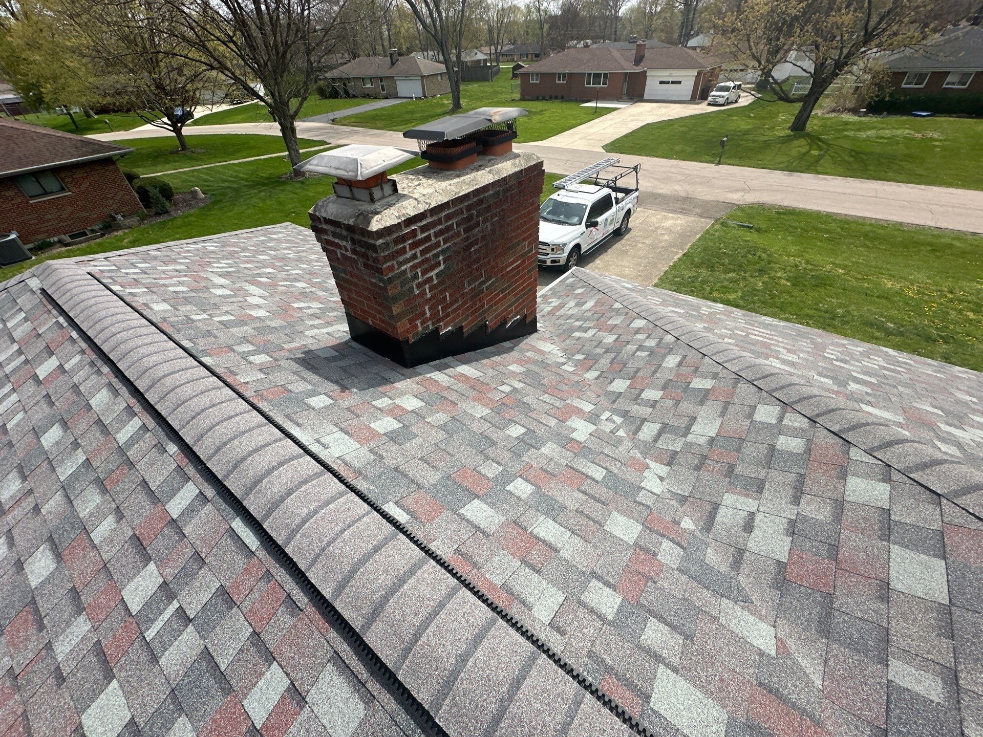 Black metal flashing sealed around the chimney base on the new roof, Beavercreek, Ohio.