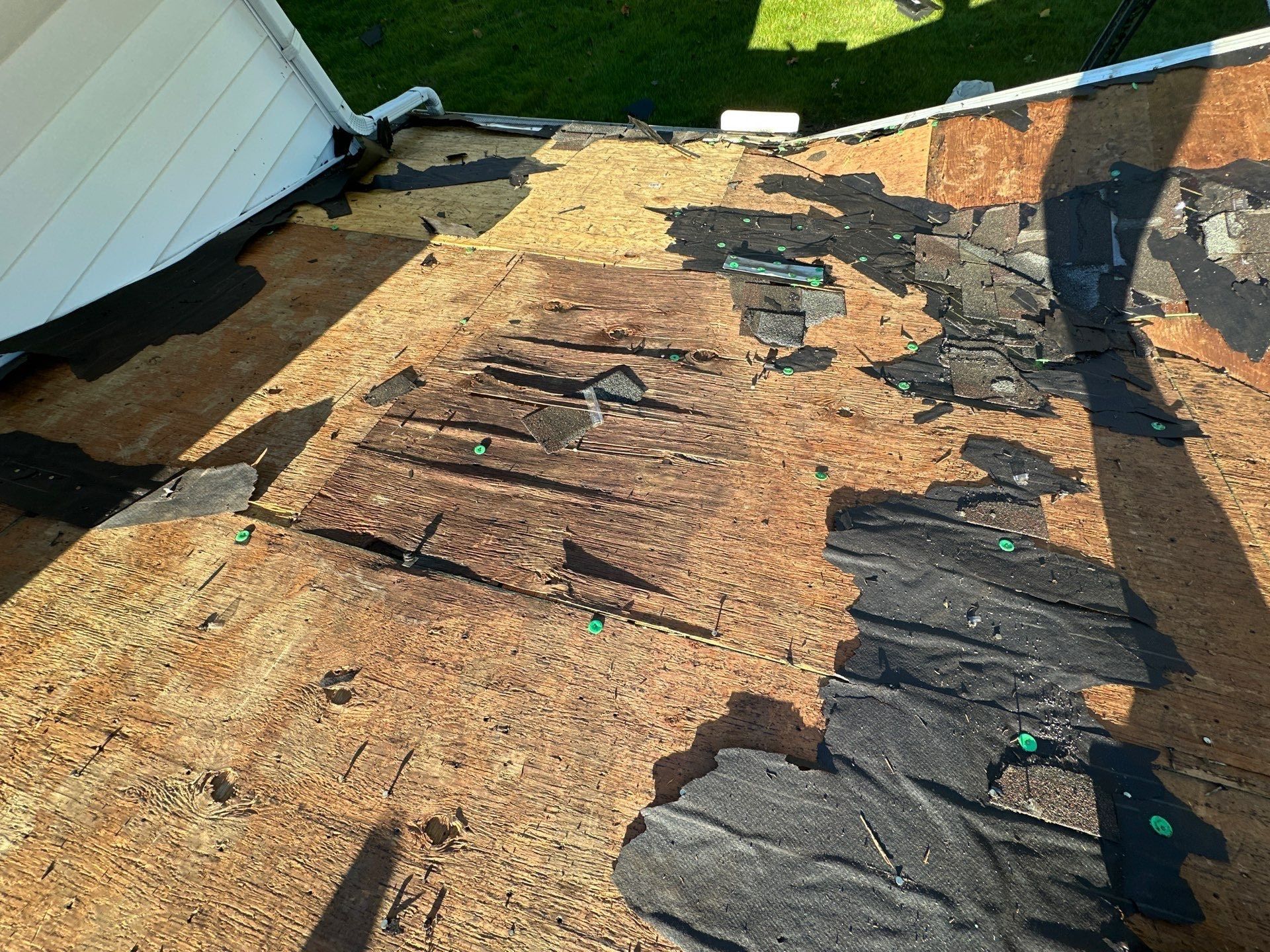 Worn deck boards and old underlayment near the top of a slope, West Carrollton, Ohio.