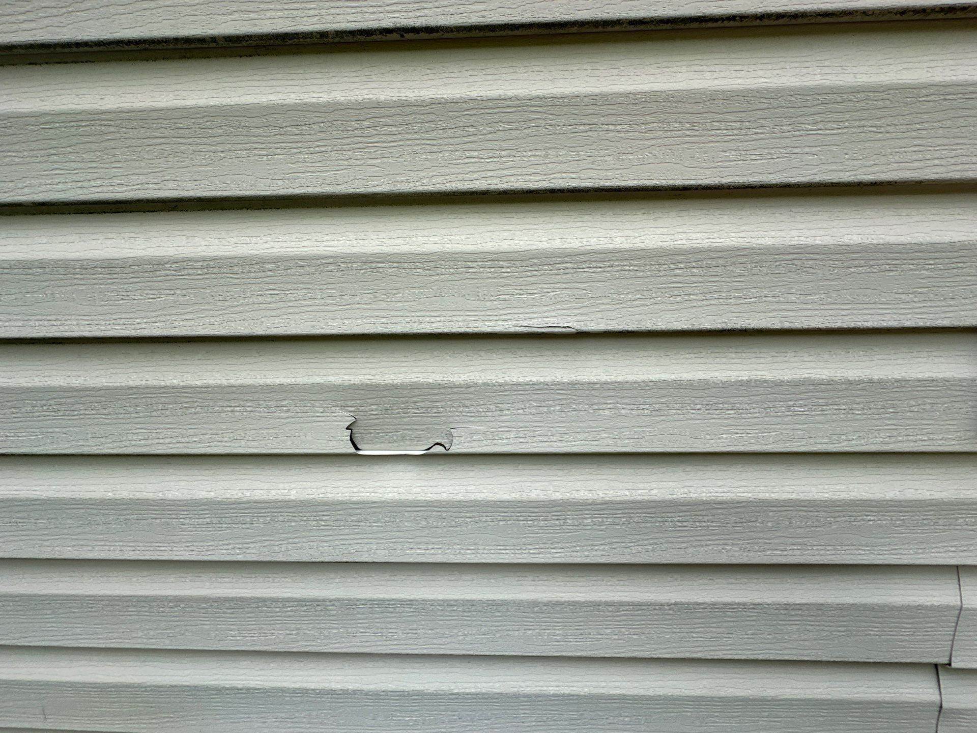 Tear through one course of vinyl siding