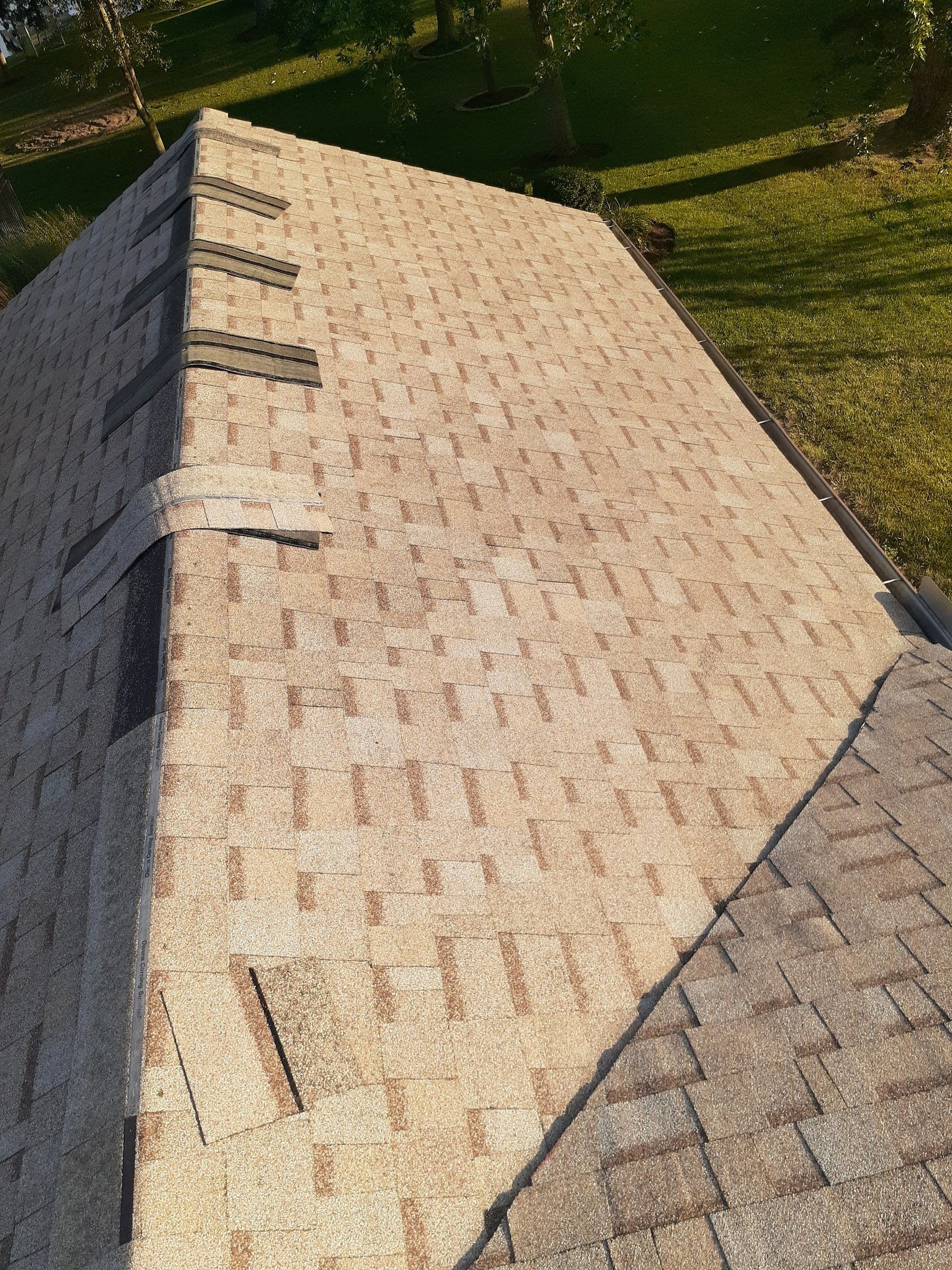 Hip cap shingles being fitted along the edge of the roof, Jamestown, Ohio.