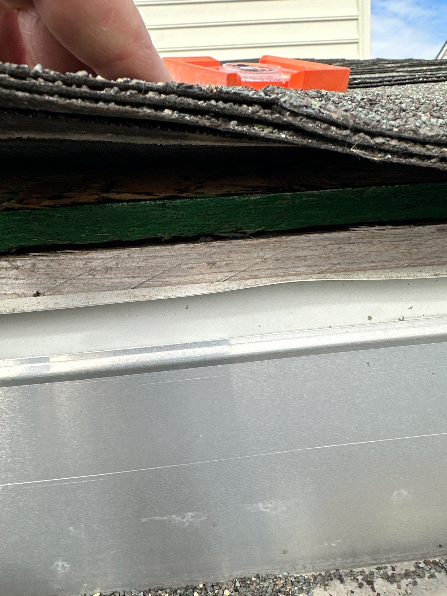 Shingle lifted at the eave, layers beneath